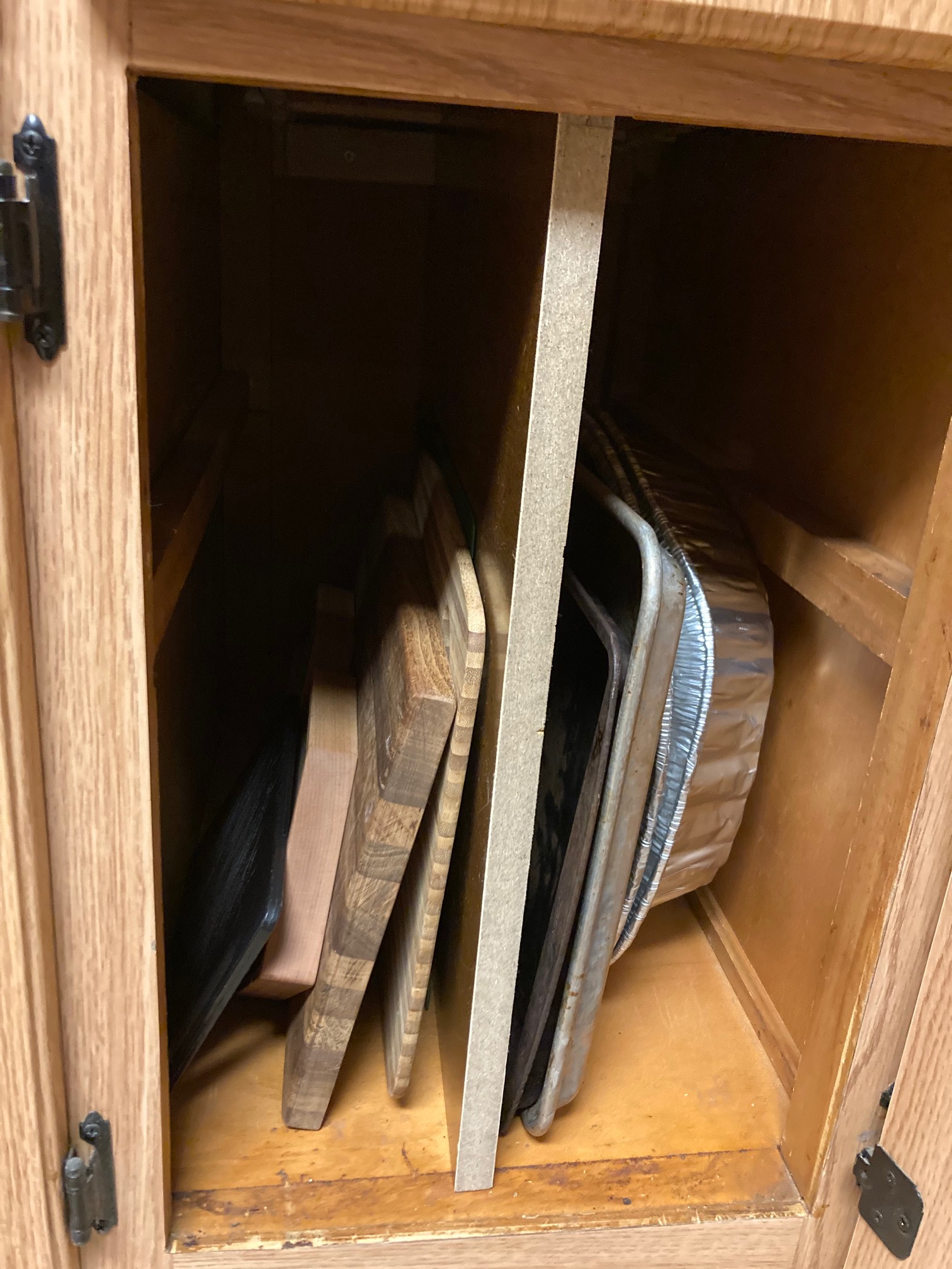 I finished putting a divider into this cabinet so that the cutting boards and baking pans could be s