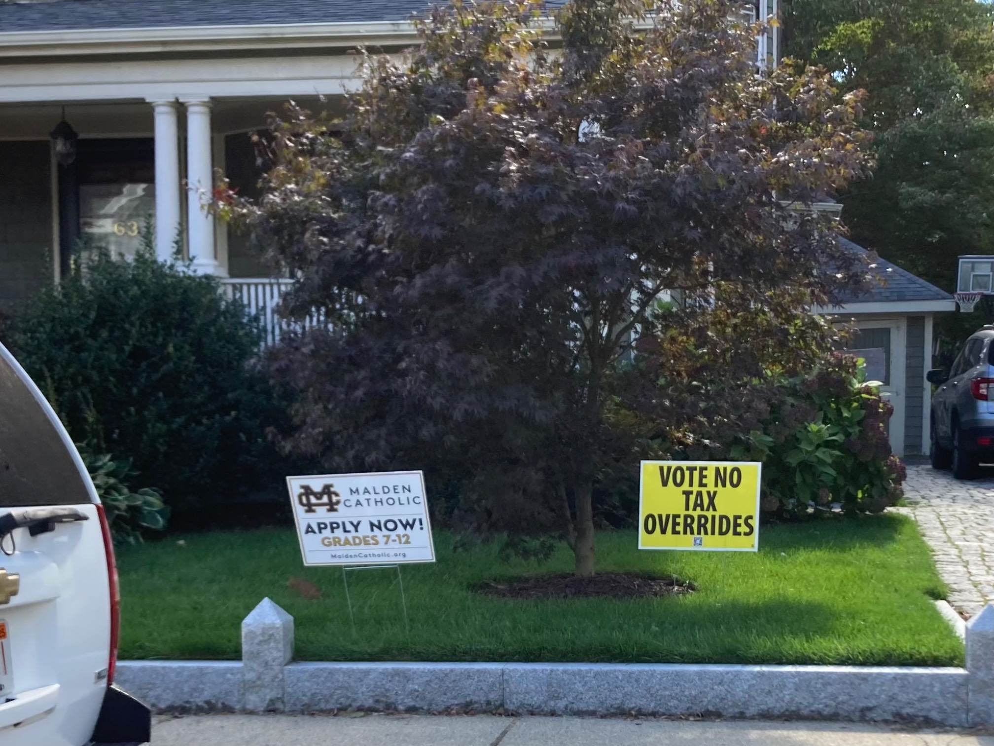 Lawn with catholic school sign and anti-tax sign