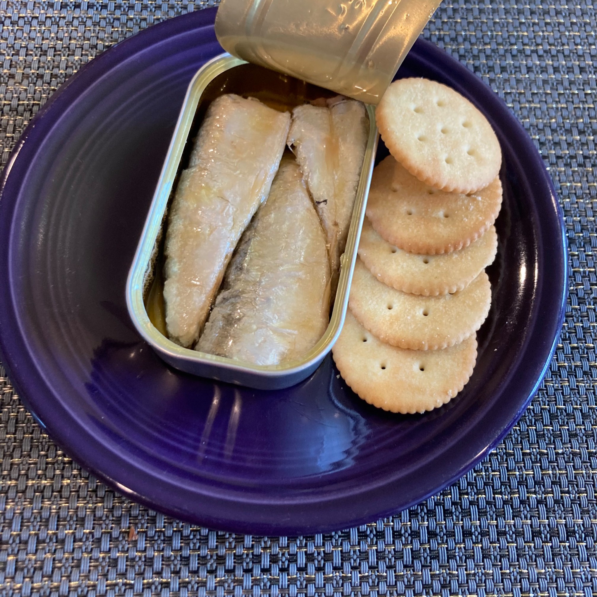 Opened can of sardines with crackers