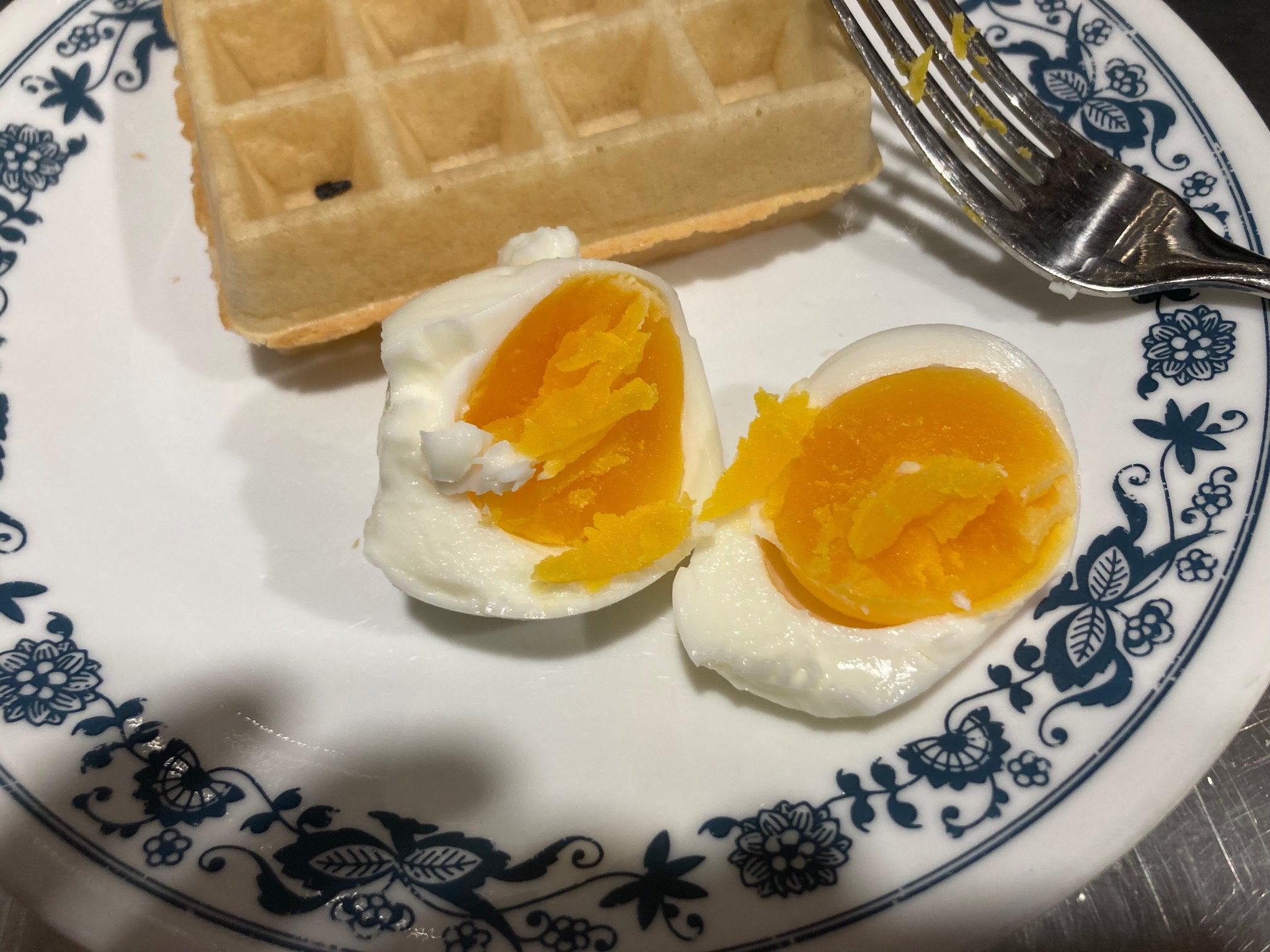 Boiled egg halves and a waffle on a plate