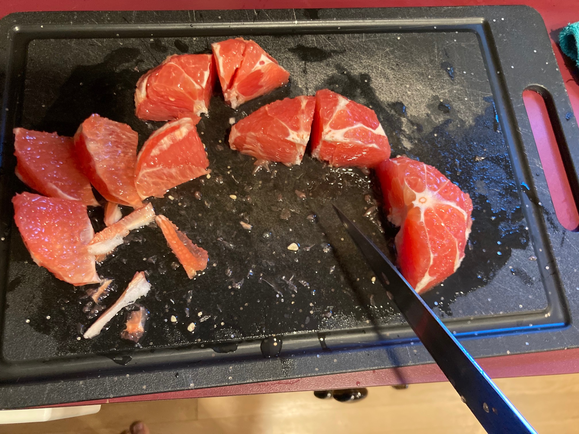 Cutting board with grapefruit pieces and knife