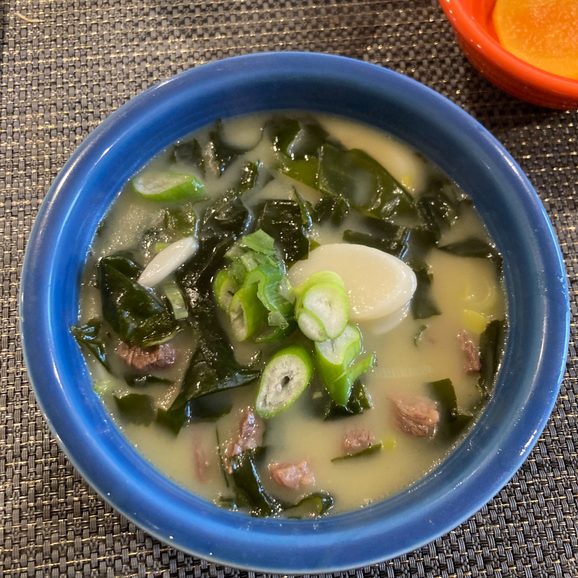 Soup with rice cakes, scallions, beef, and seaweed