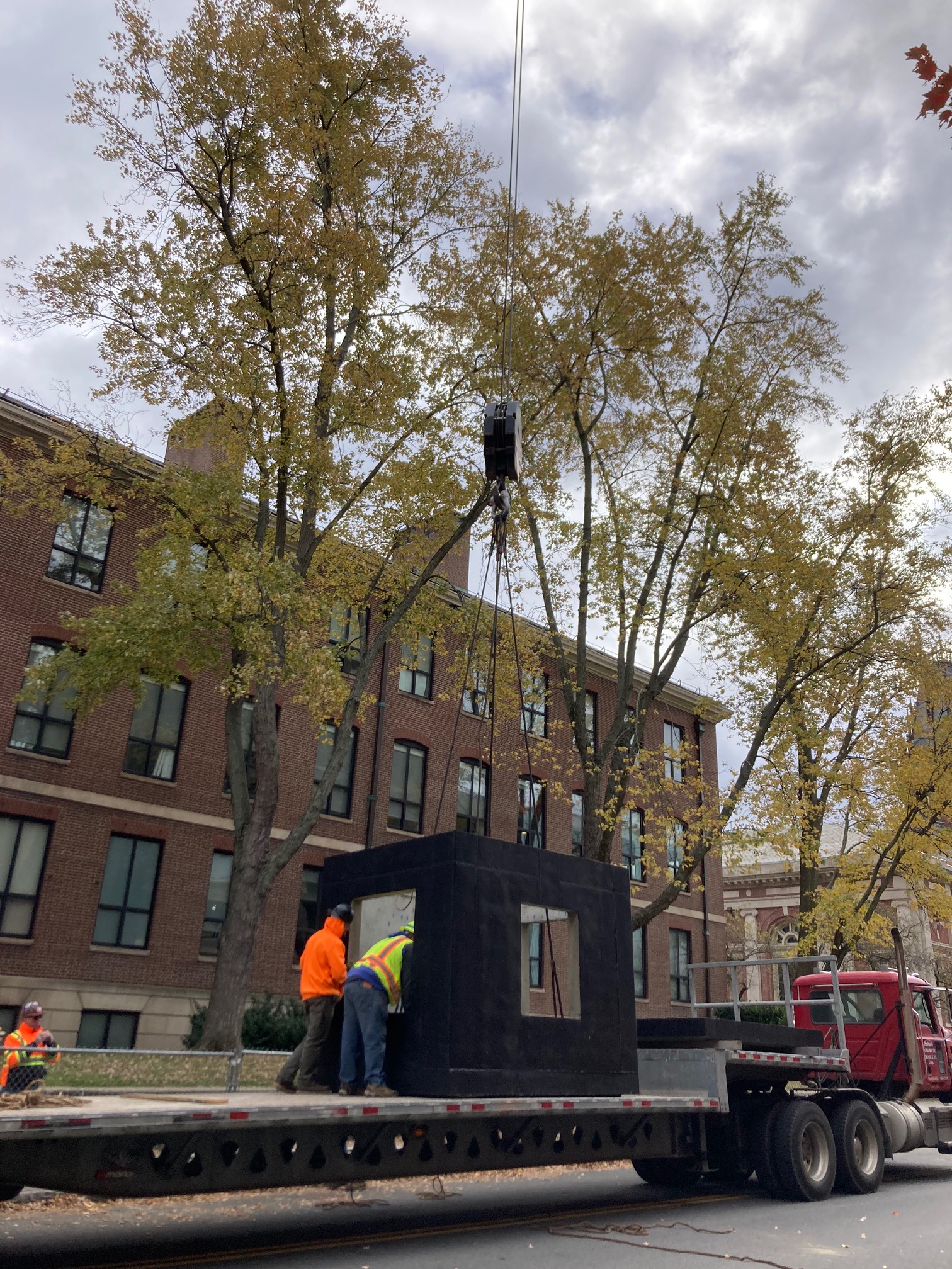 Crane lifting large black cube