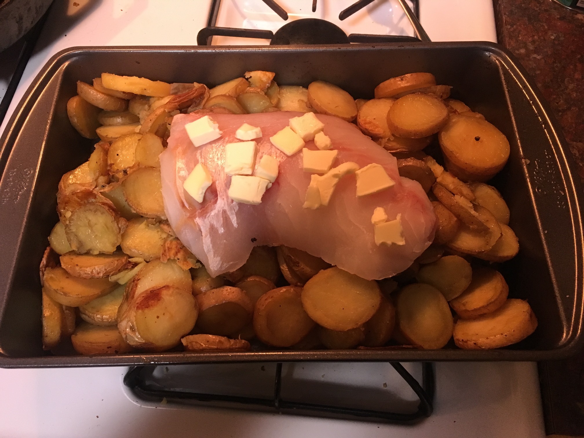 This recipe is very '50s. Bake potato slices, then bake fish with butter on top of it.