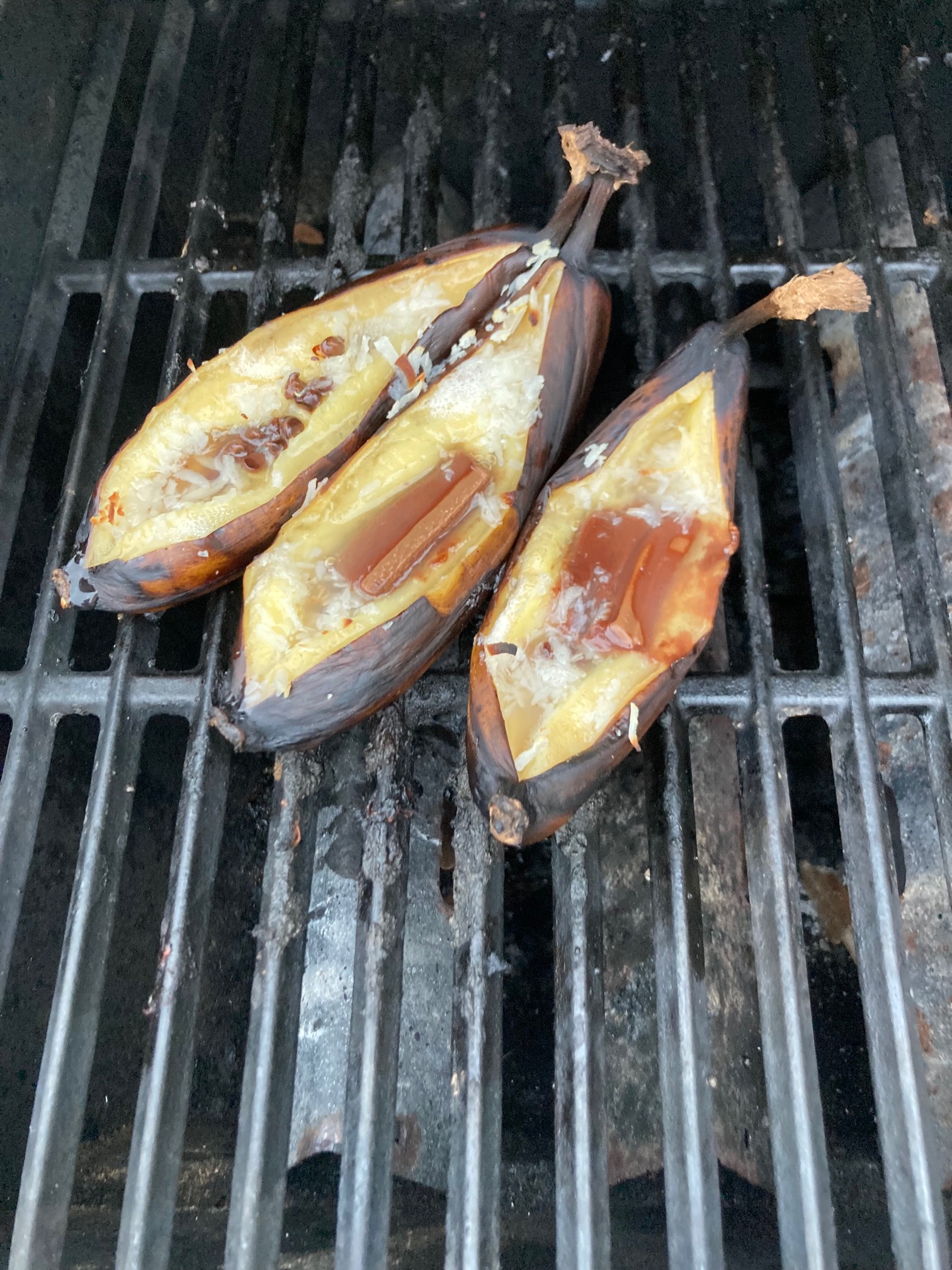 Split bananas on grill containing liquid