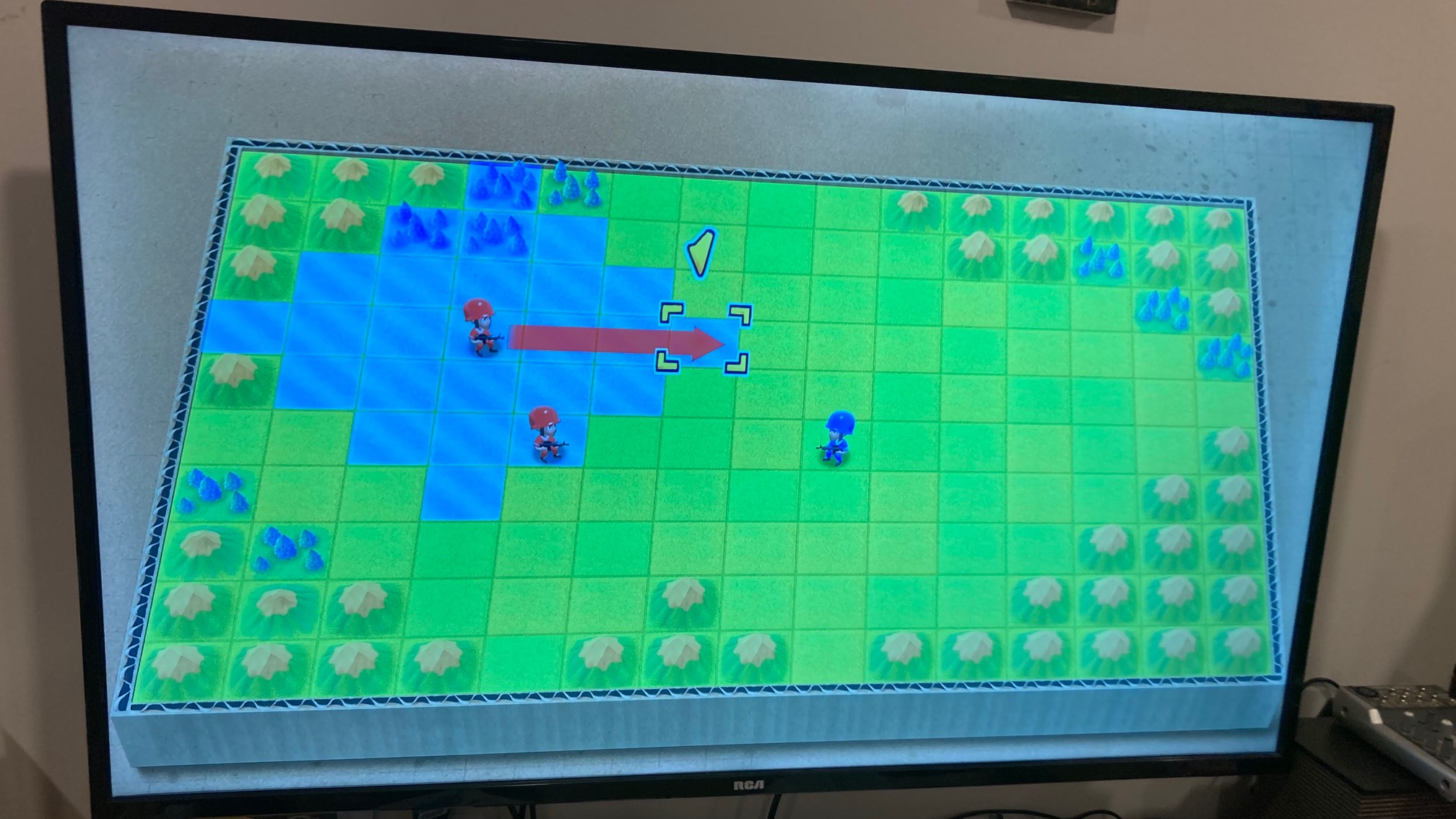 TV showing game with gridded field in cardboard container