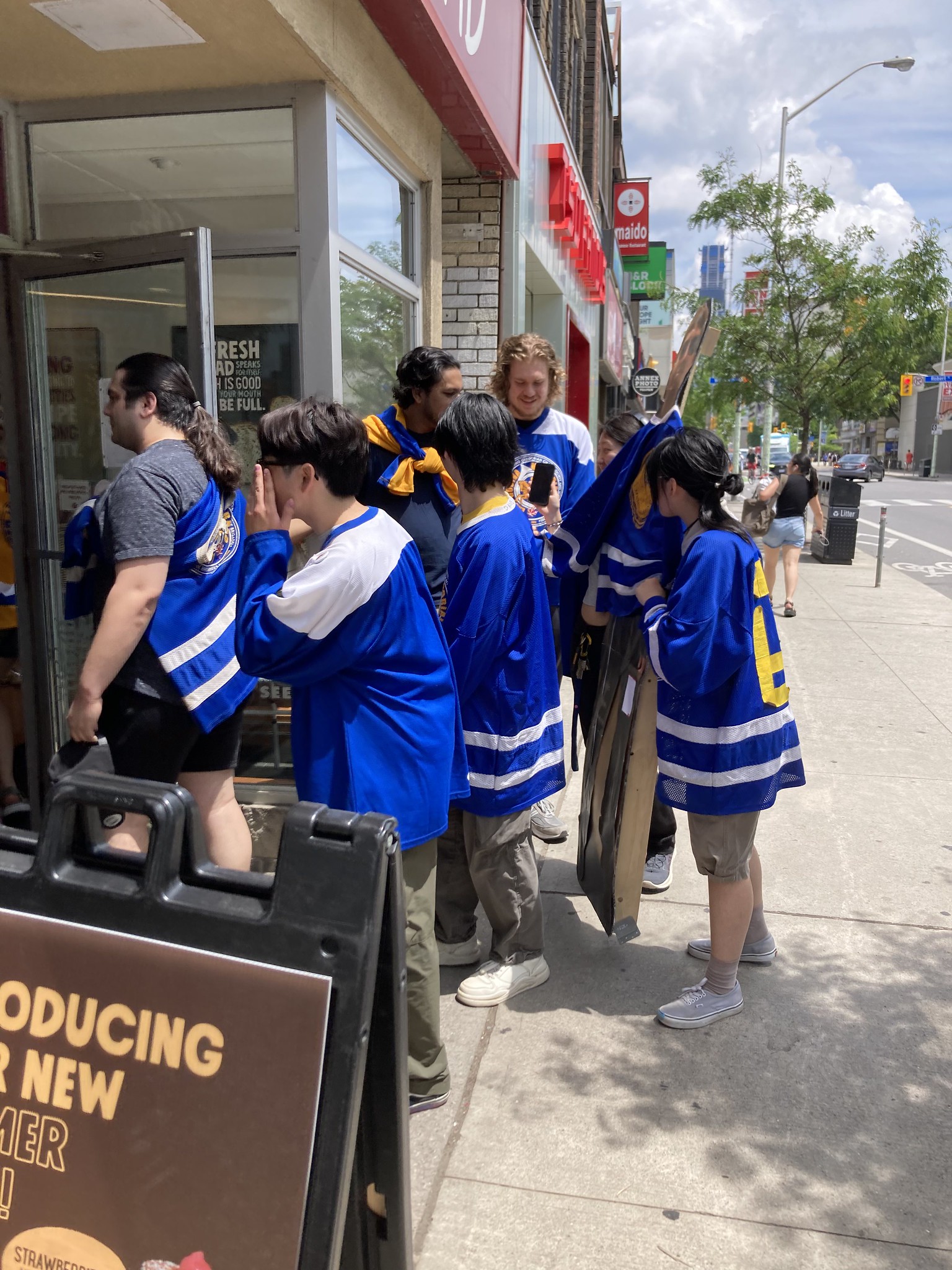 People in blue uniforms carrying a cardboard cutout