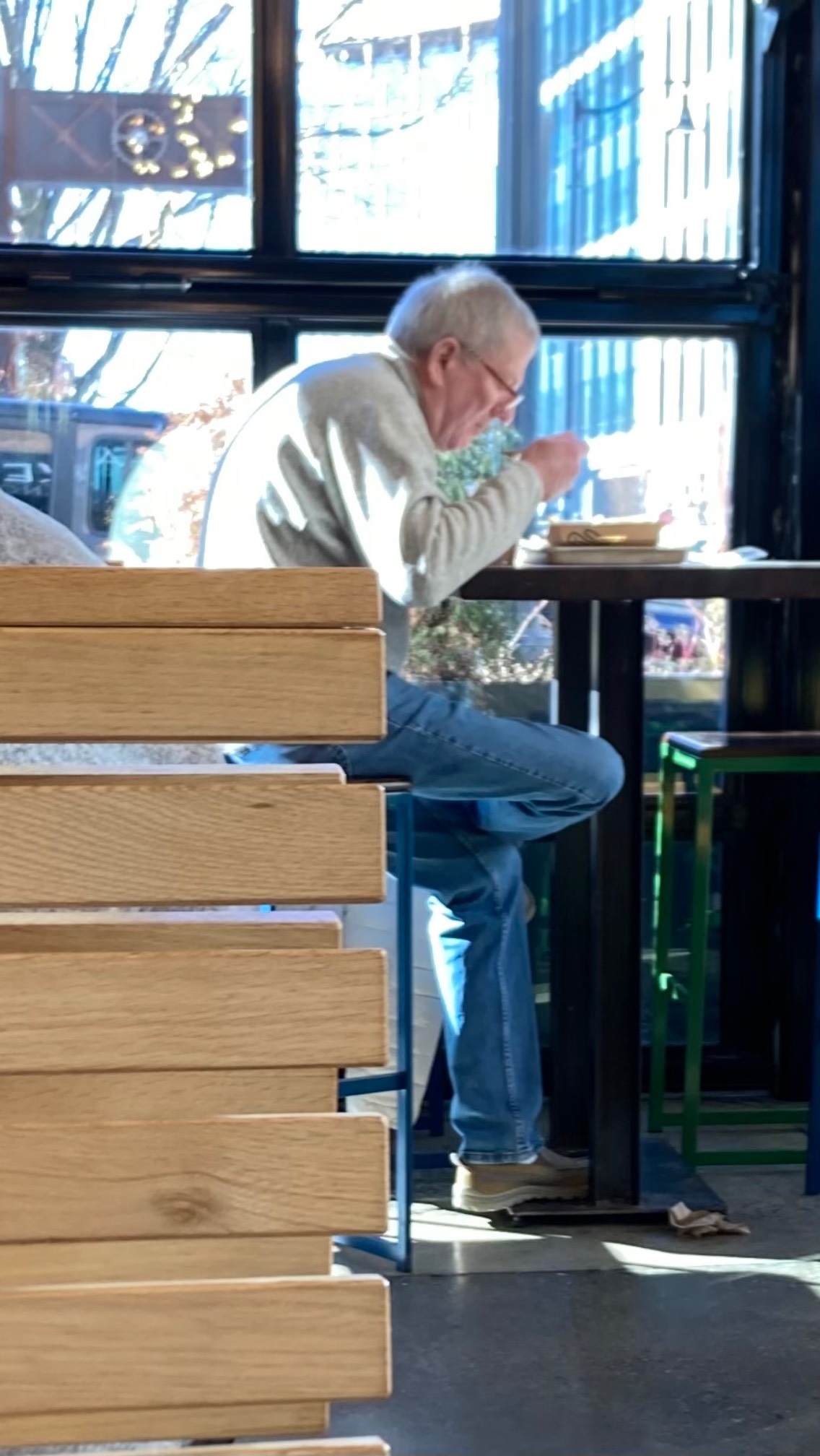 White-haired older White man sitting at high table