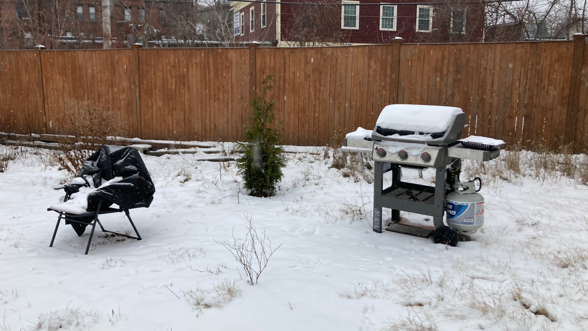 Grill cover on chair, snow on grill