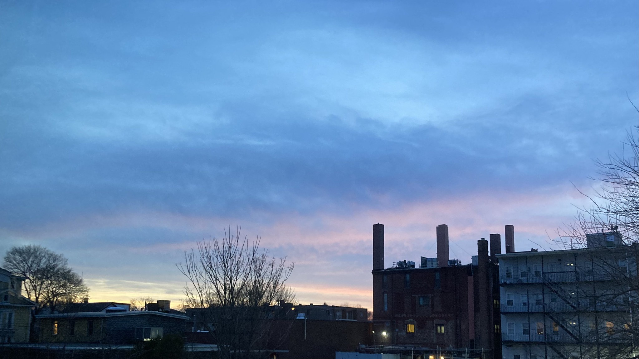 Blue and purple and yellow sky over buildings