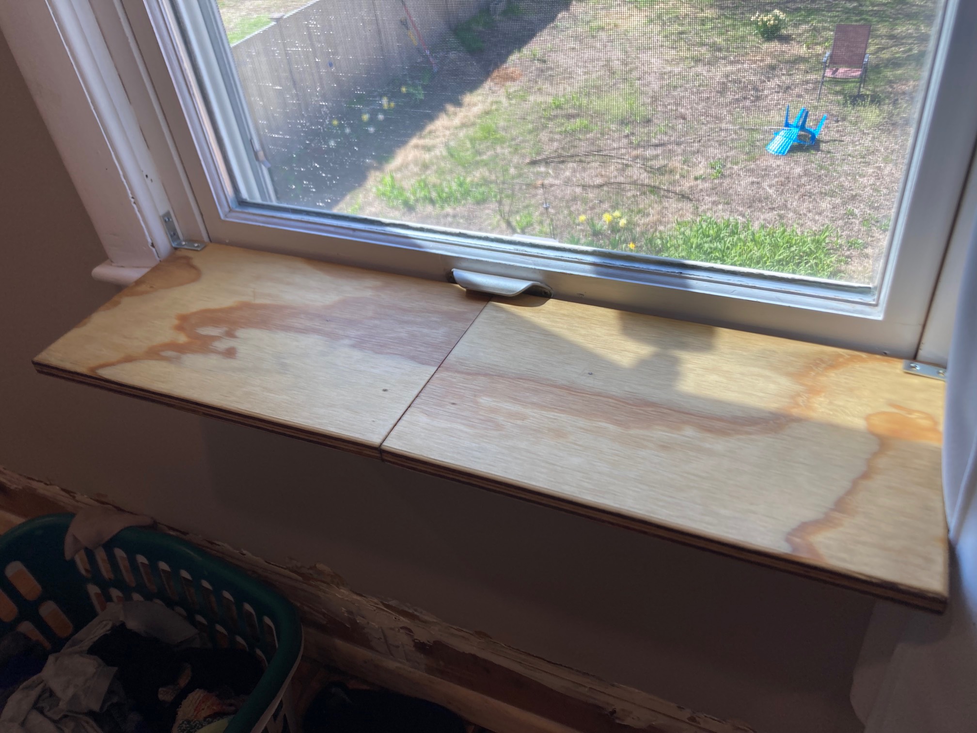 Darker plywood shelf at window