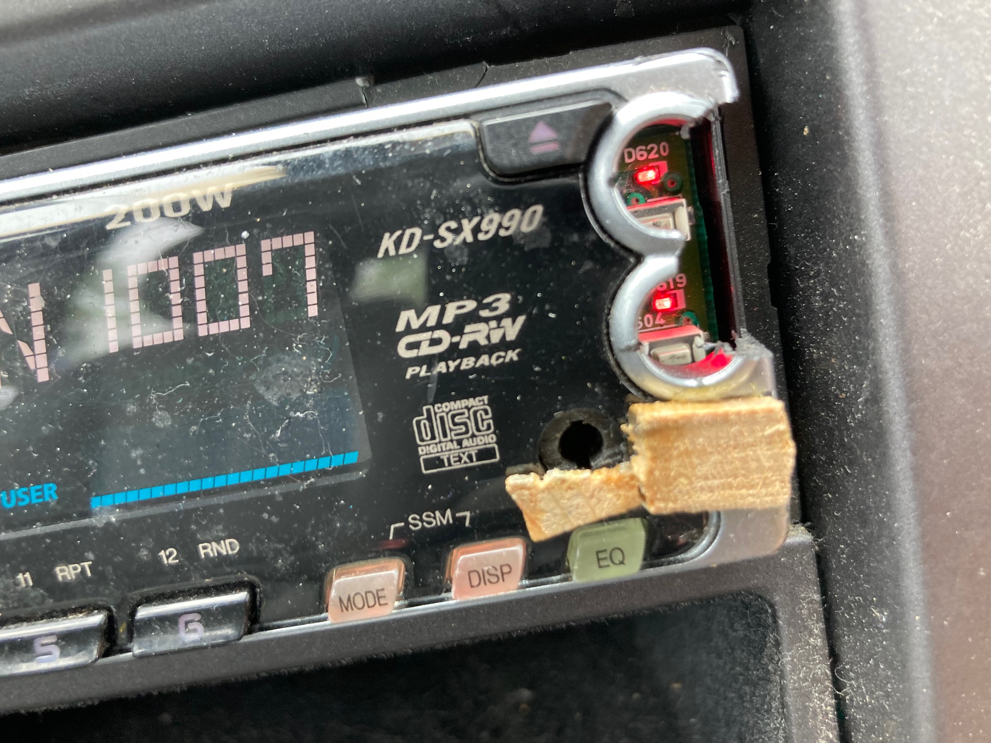 Car stereo with two small bits of wood glued under the aux port