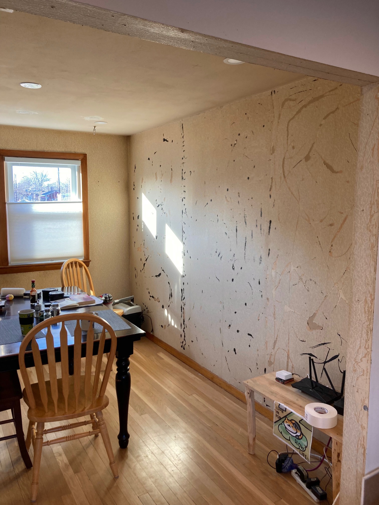 Room with white wallpaper with black and yellow glue streaks