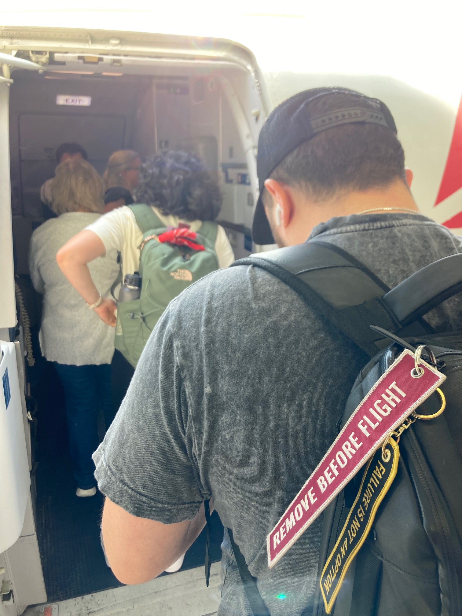 Man with “remove before flight” tag on backpack