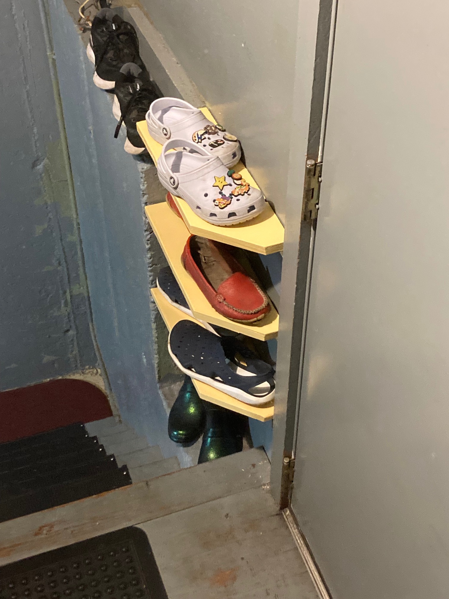 ellow boards attached to wall with shoes on them