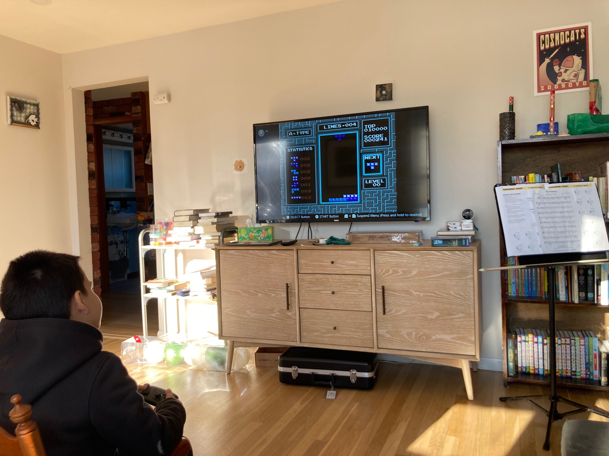 Kid in front of living room TV with Tetris on it
