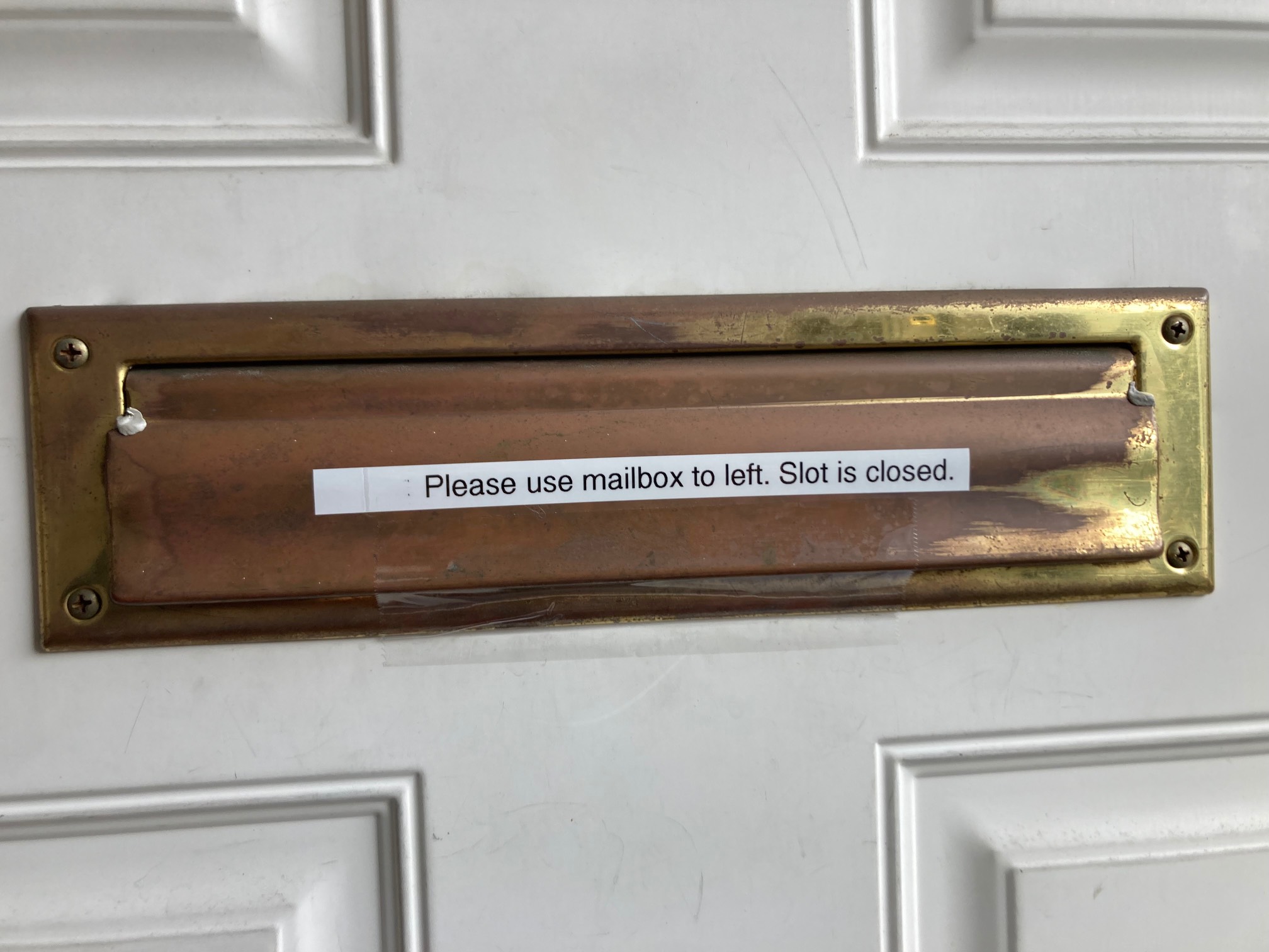 “Please use mailbox to left. Slot is closed” label on mail slot.