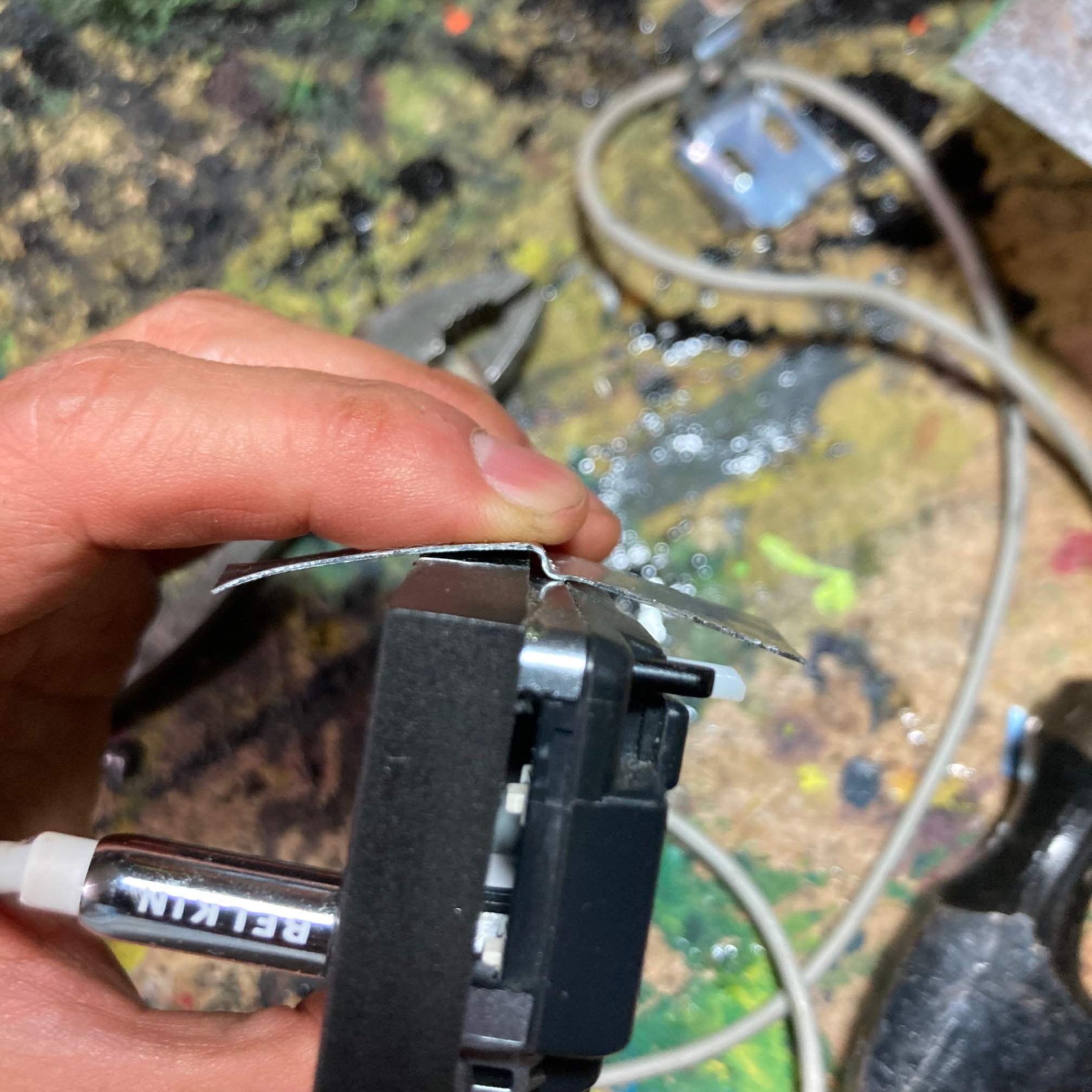 Strip of sheet metal being bent into a U-shaped clip fitting to a car stereo face