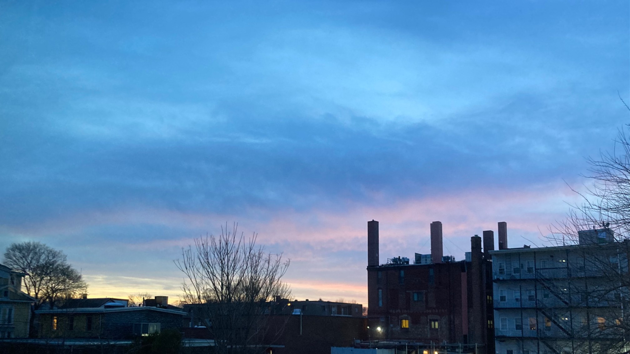 Blue clouds with red highlights over buildings