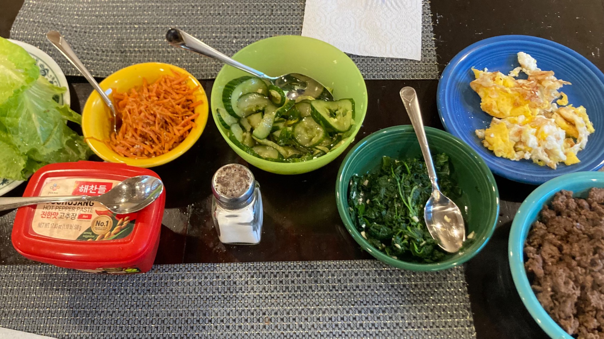 Lettuce, carrots, cucumbers, spinach, eggs, beef, all seasoned and in bowls