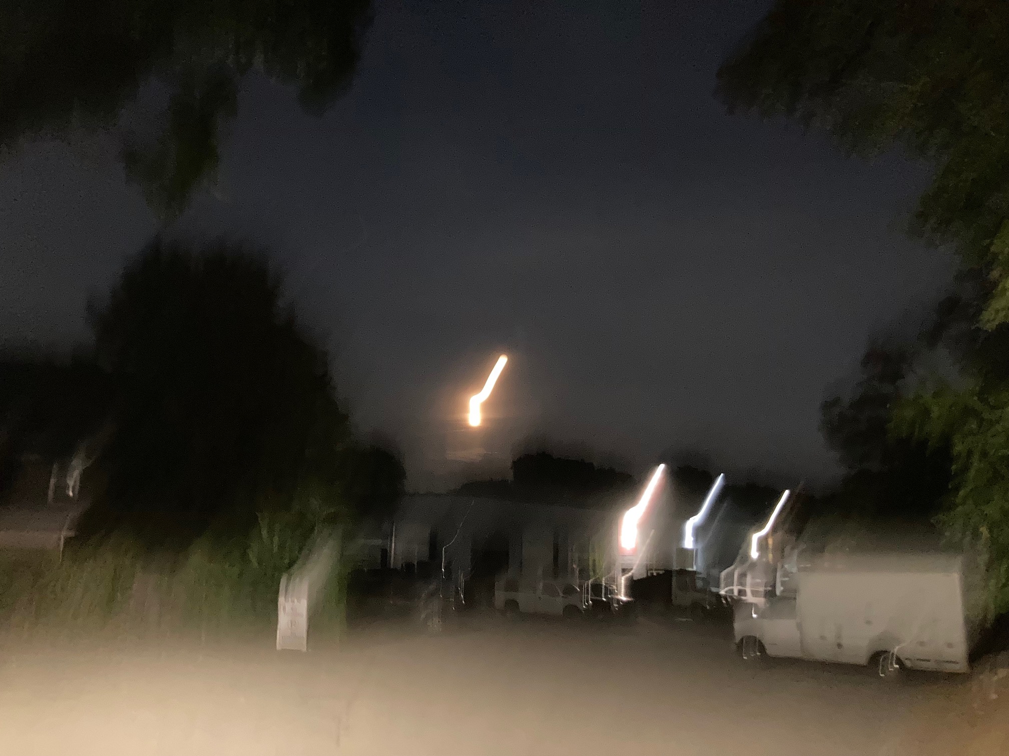Night scene with light streaks where the moon and street lamps should be