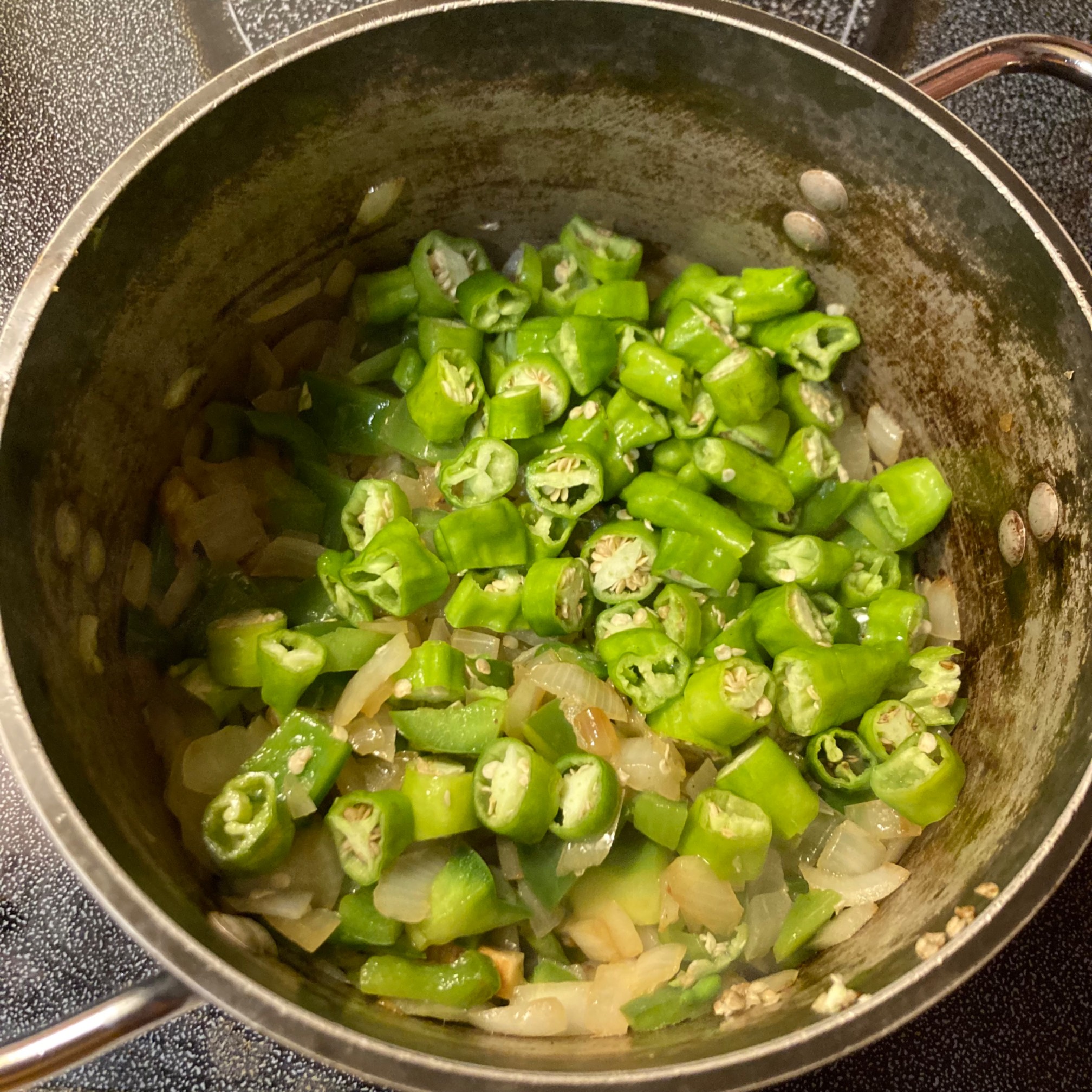Shishito peppers and green peppers and onions in pot
