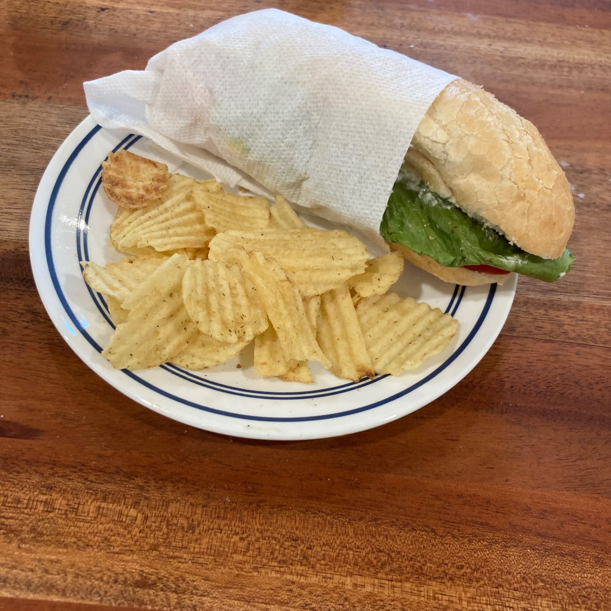 Wrapped sandwich and chips on plate