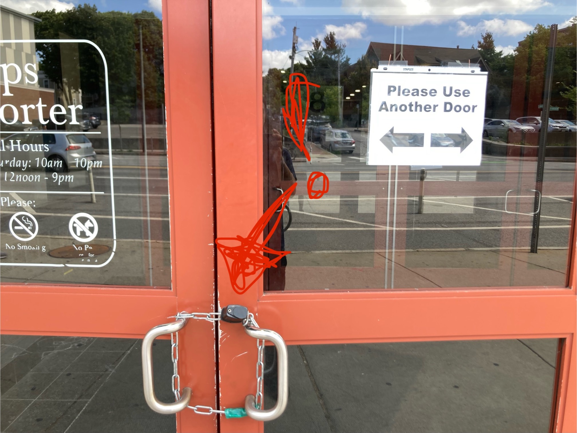 Please use other door sign with an arrow pointing at a door that is secured by a chain