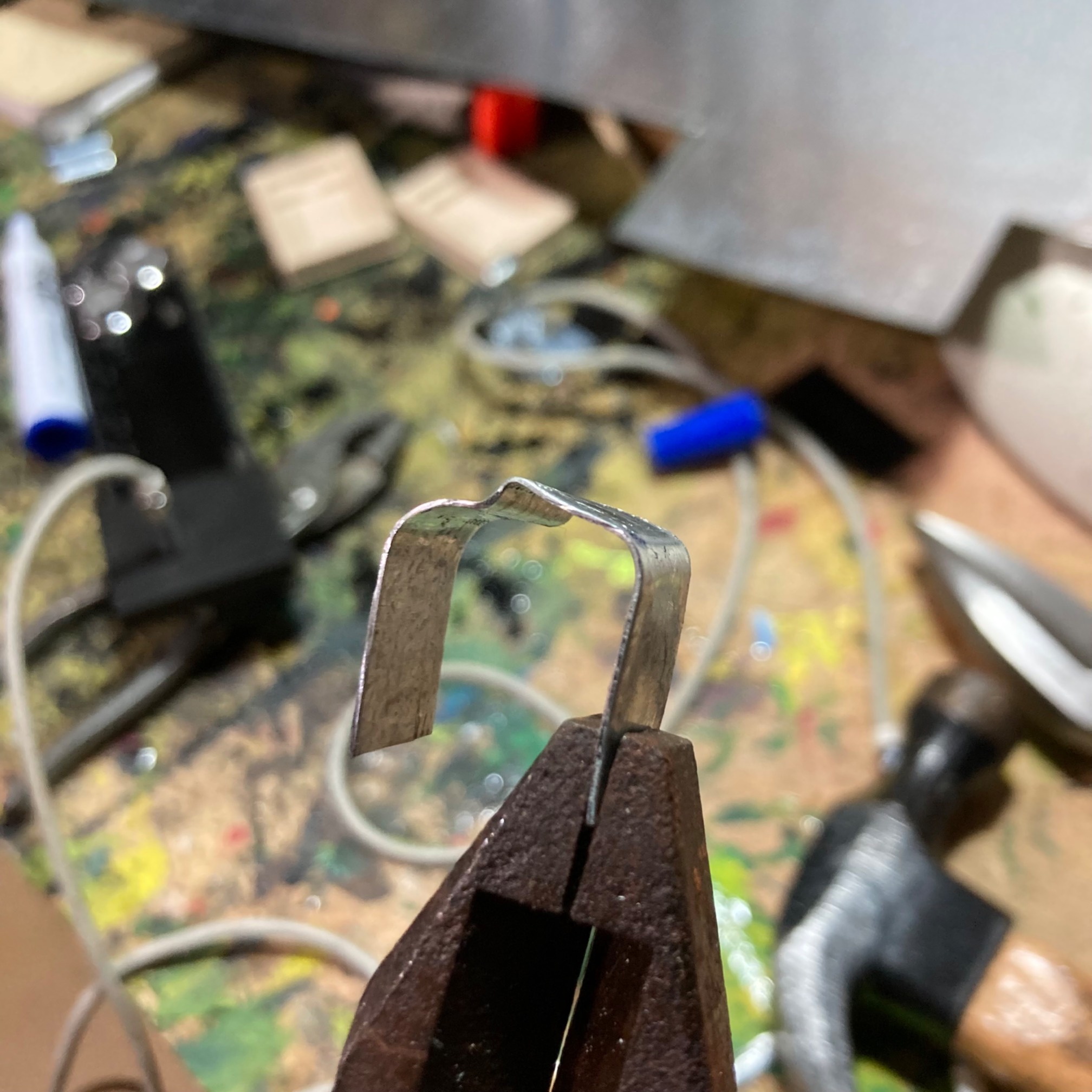 Strip of sheet metal being bent into a U-shaped clip fitting to a car stereo face