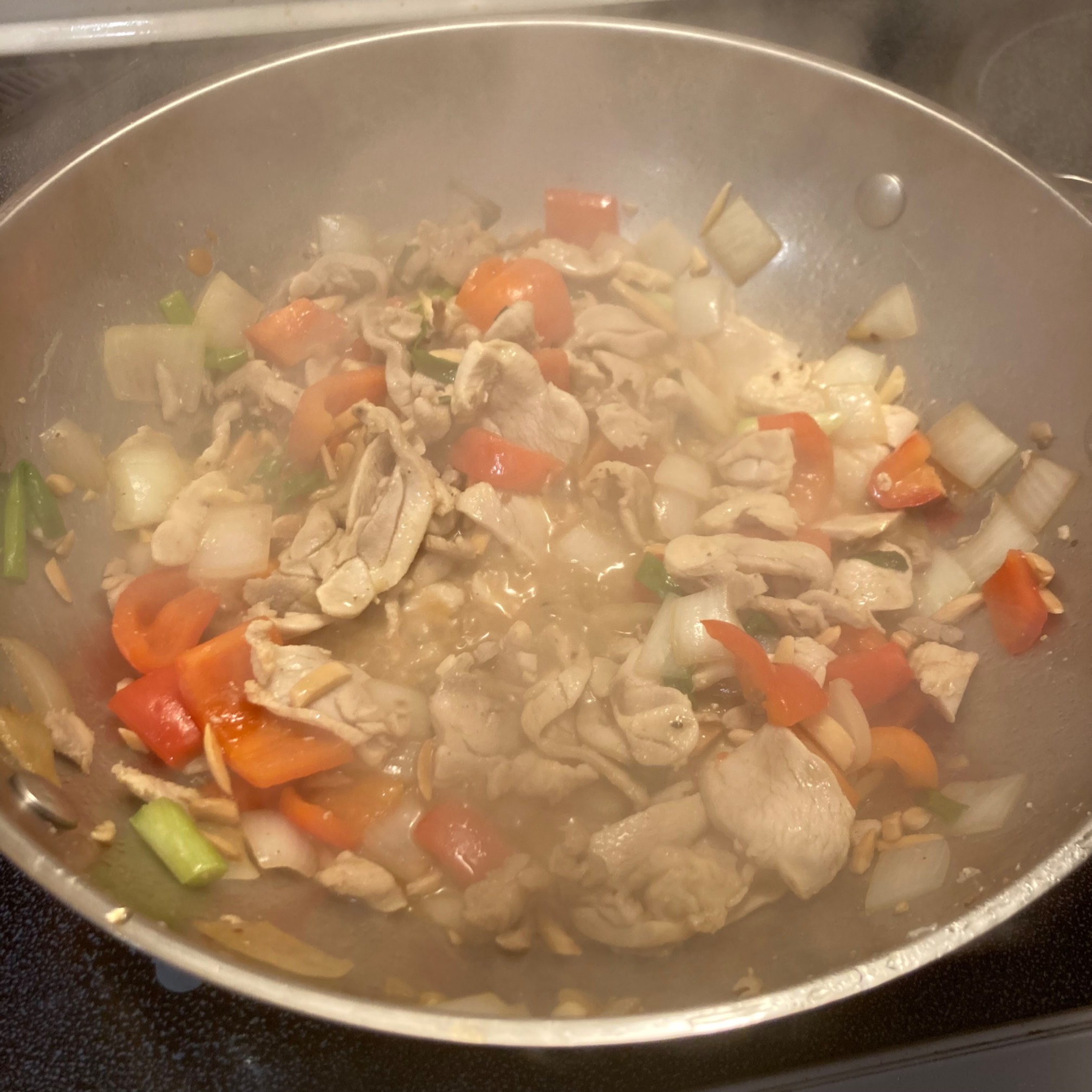 Chicken, pepper, onions, basil in a wok