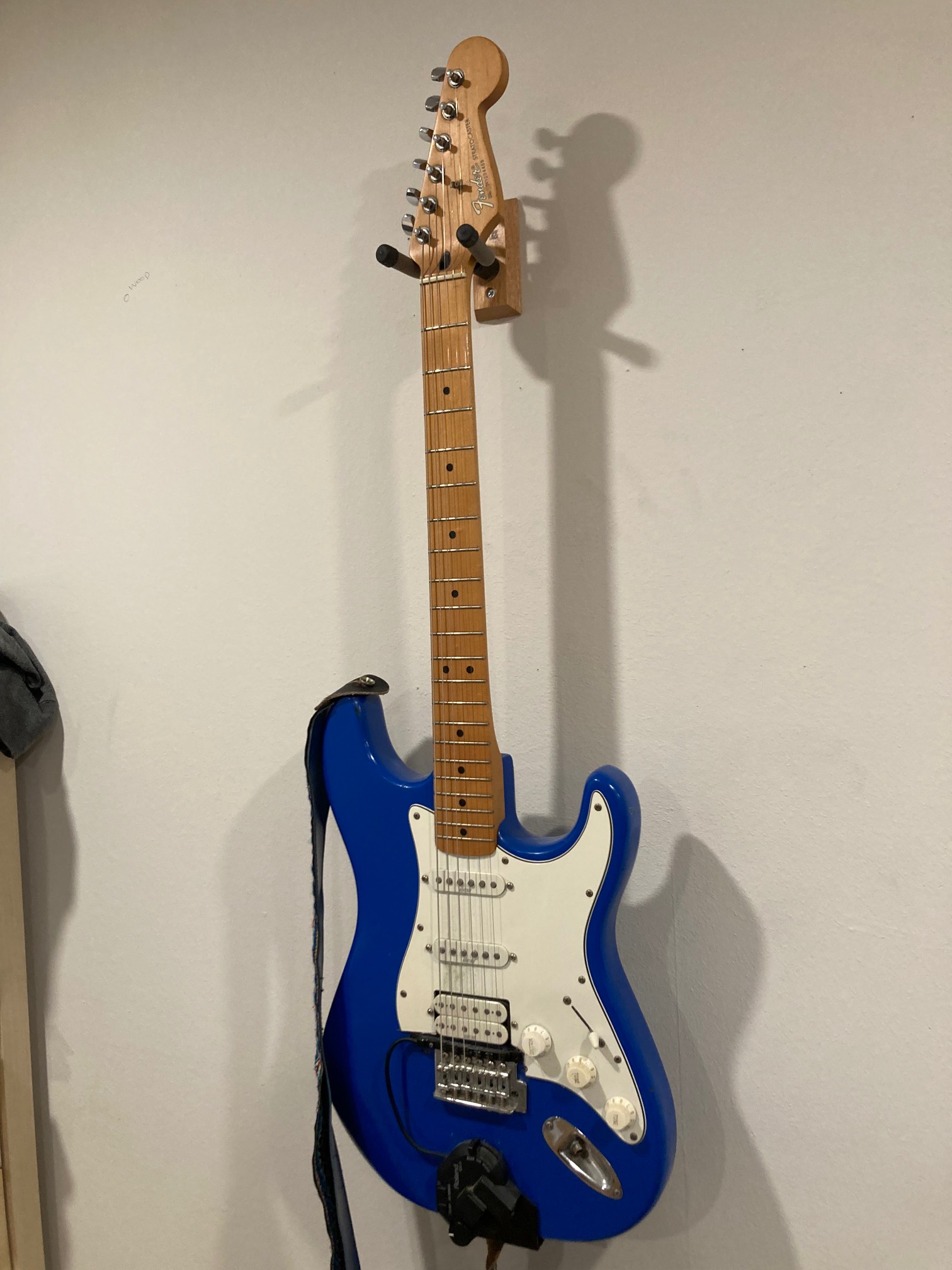 Electric guitar on hanger on wall