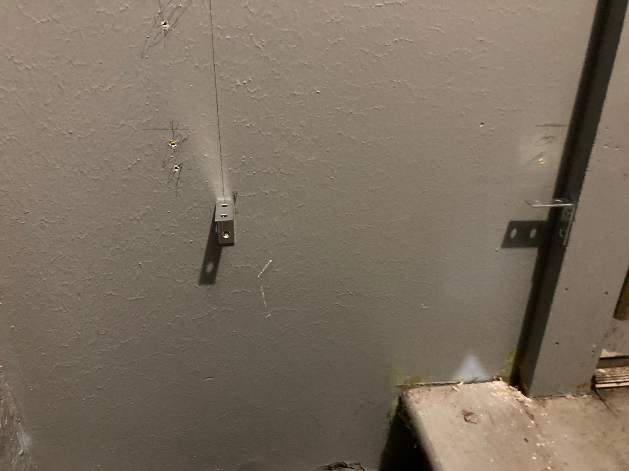 Wall by door jamb with two L brackets