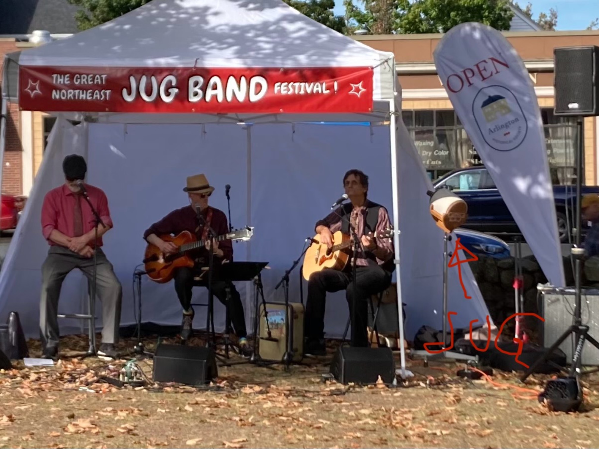 Harmonica, guitar, and bass player with a jug sitting to the side