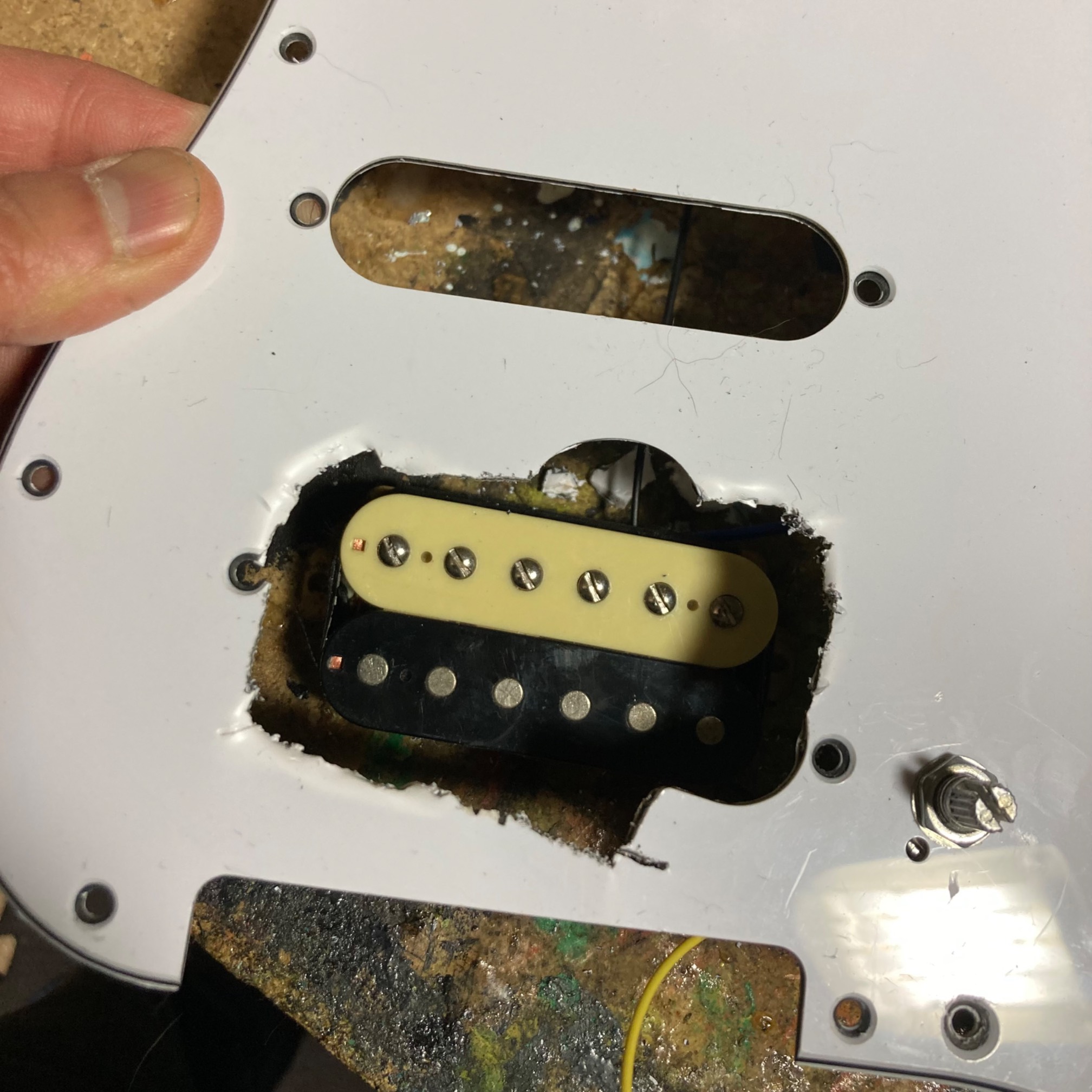 With a bolt cutter, pliers, and a hacksaw, you can gnaw a right-enough size hole in a pickguard in a