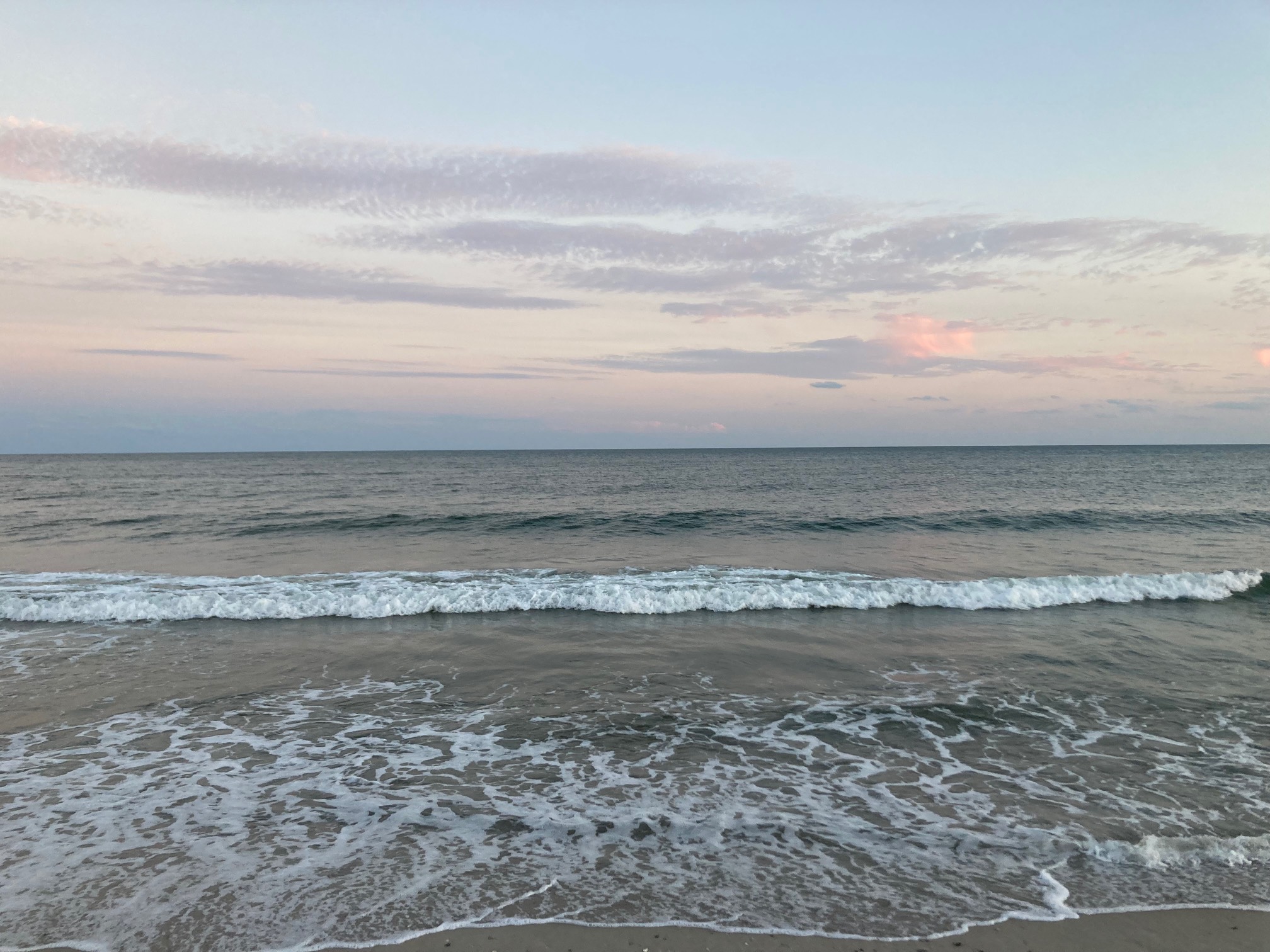Clouds and red-orange sky over ocean shore
