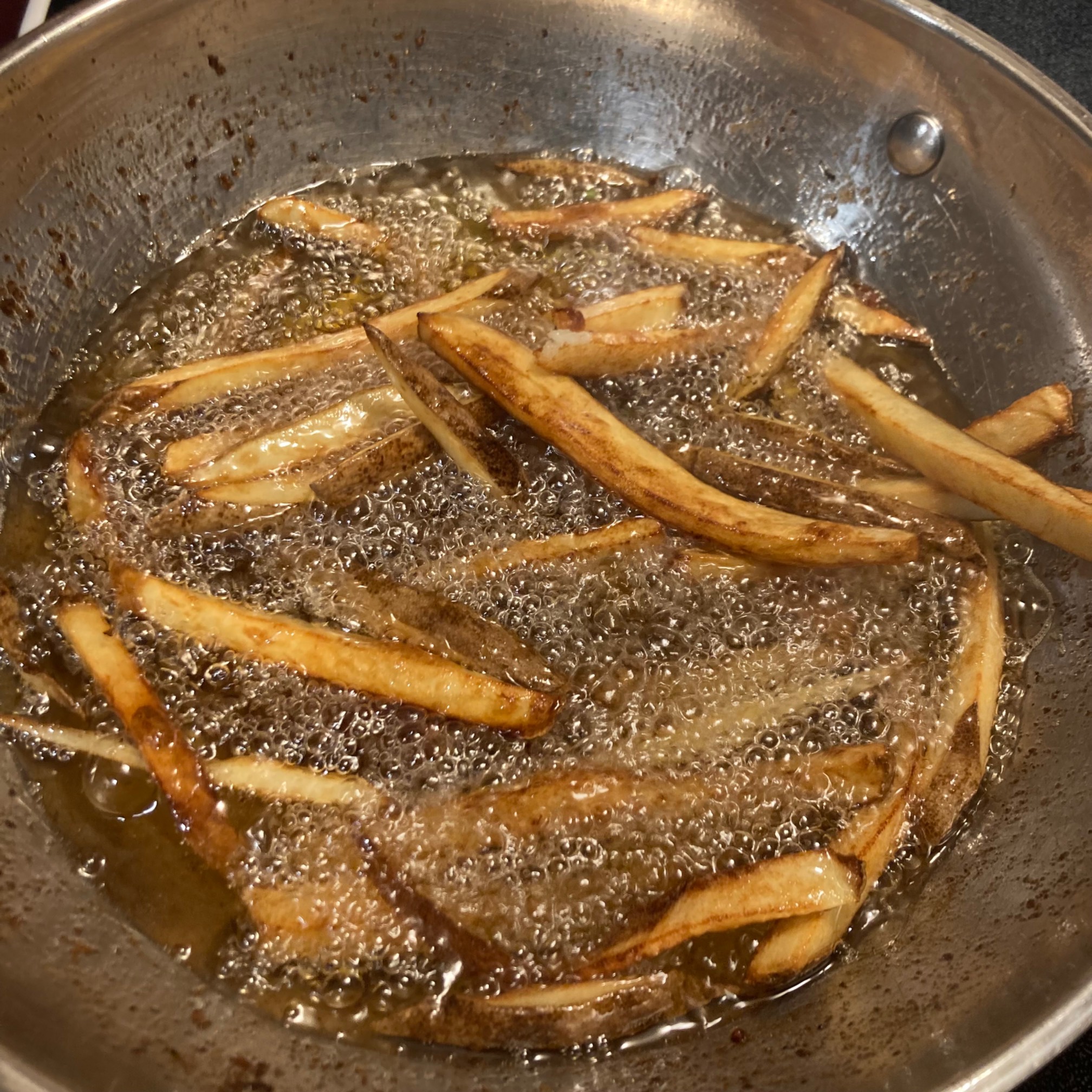 Finished fries in a wok of oil