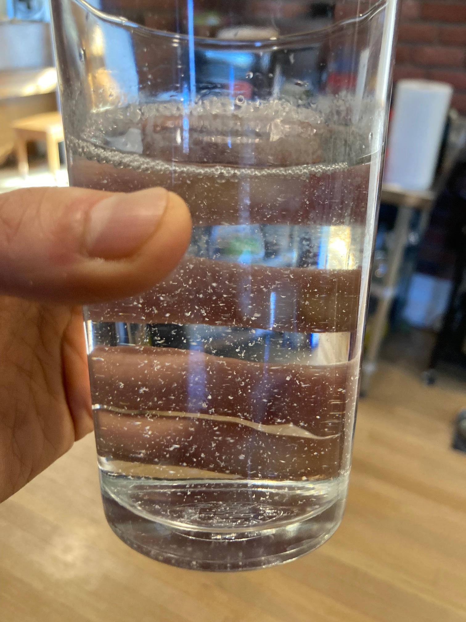 Glass of liquid with plastic shavings