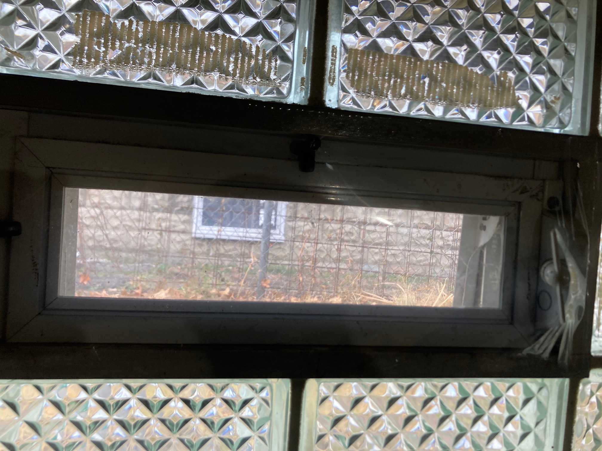 Glass window with a smaller rectangular window in it covered by plastic