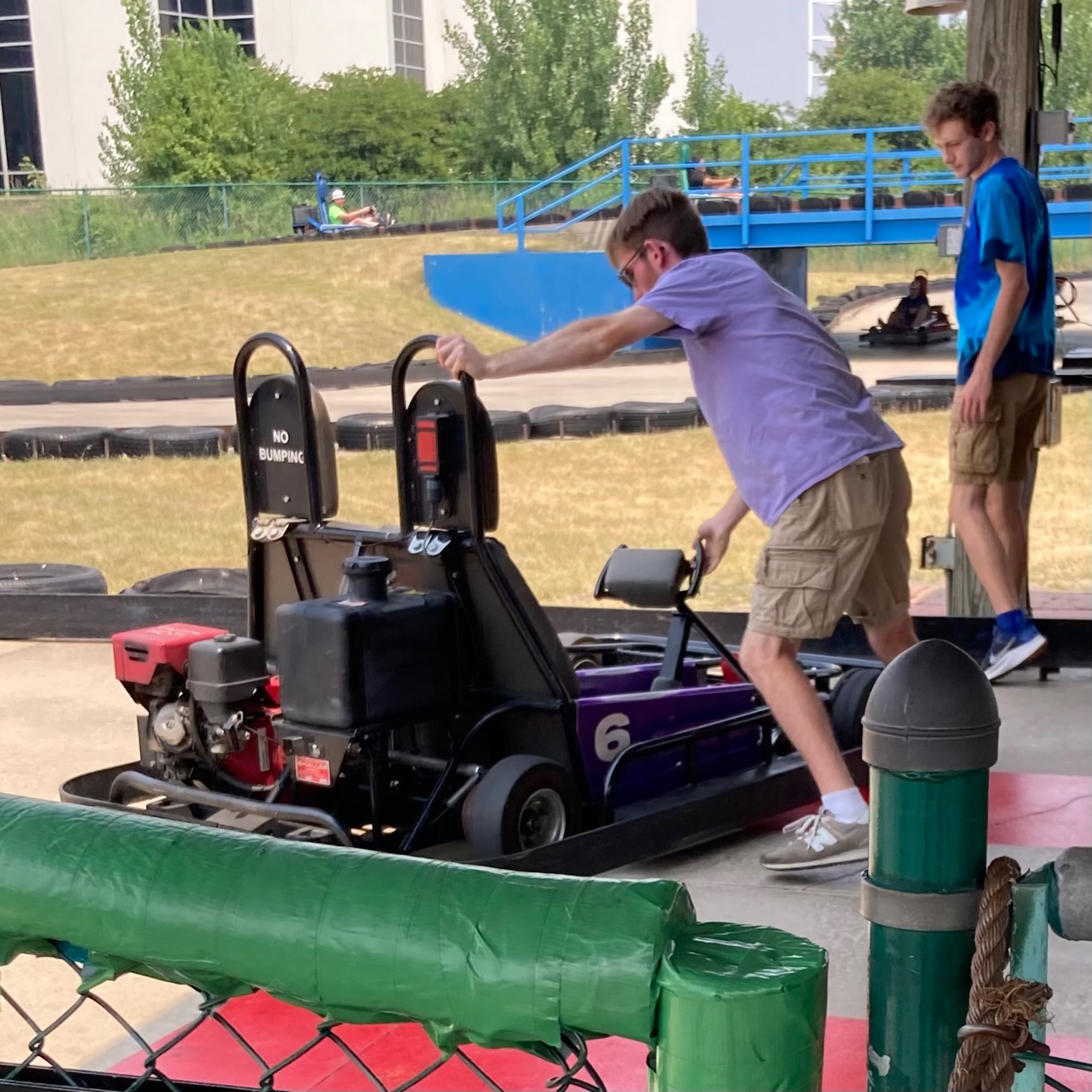 This guy is a go-kart test driver. It could very well be a high-status position at this go-kart/mini