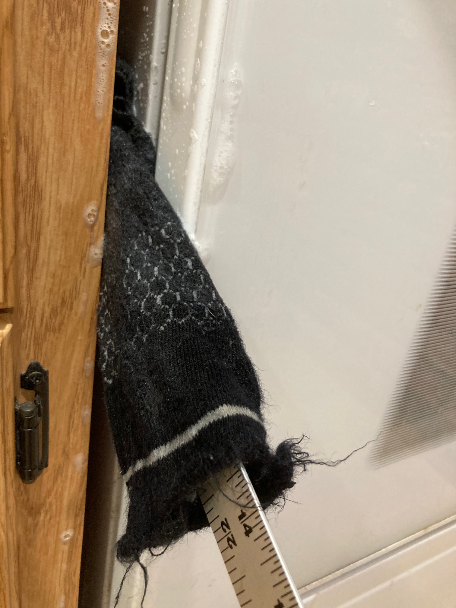 Sock on metal yardstick in gap between cabinet and stove