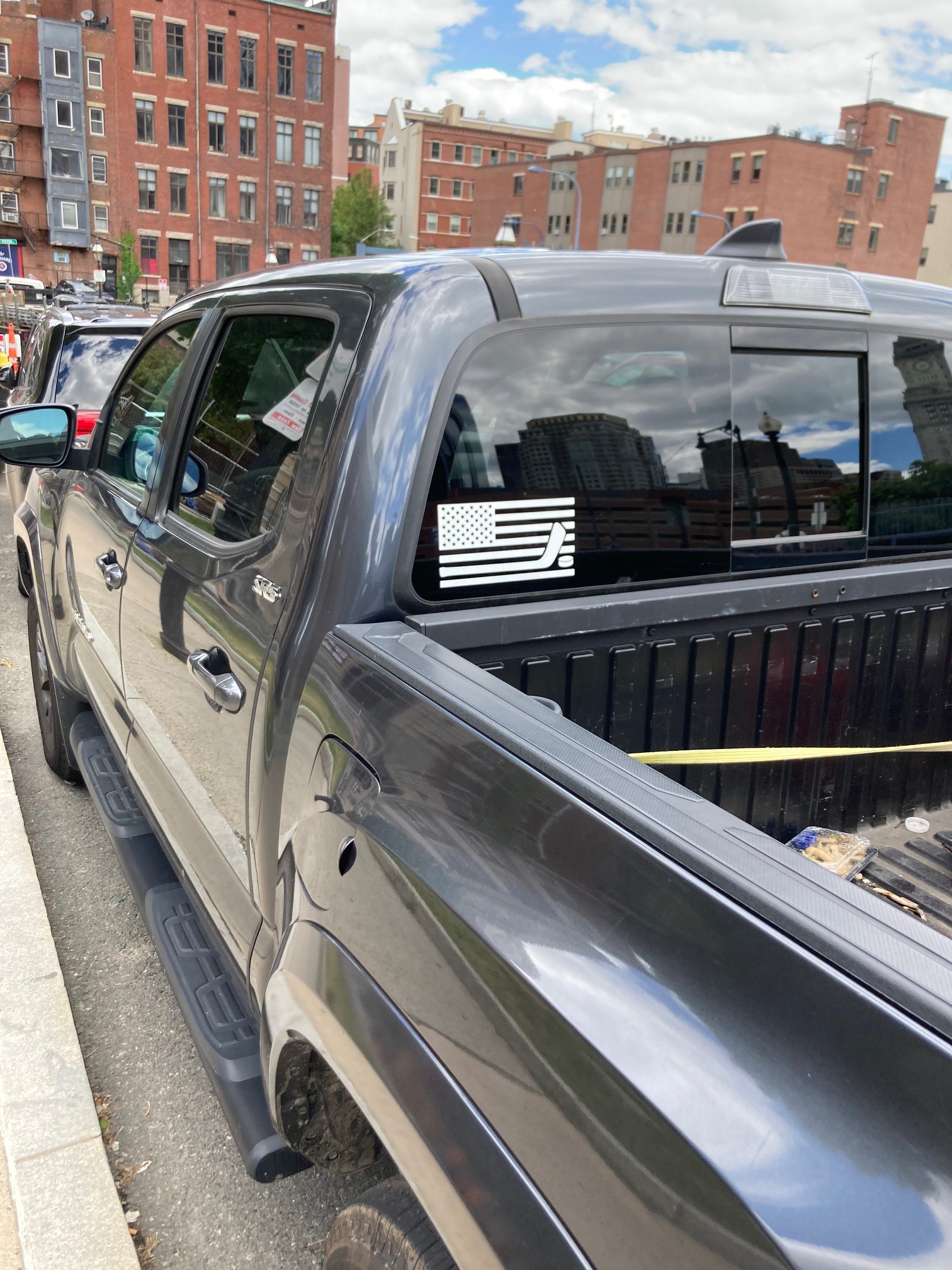 Truck with sticker with version of flag with a hockey stick on it
