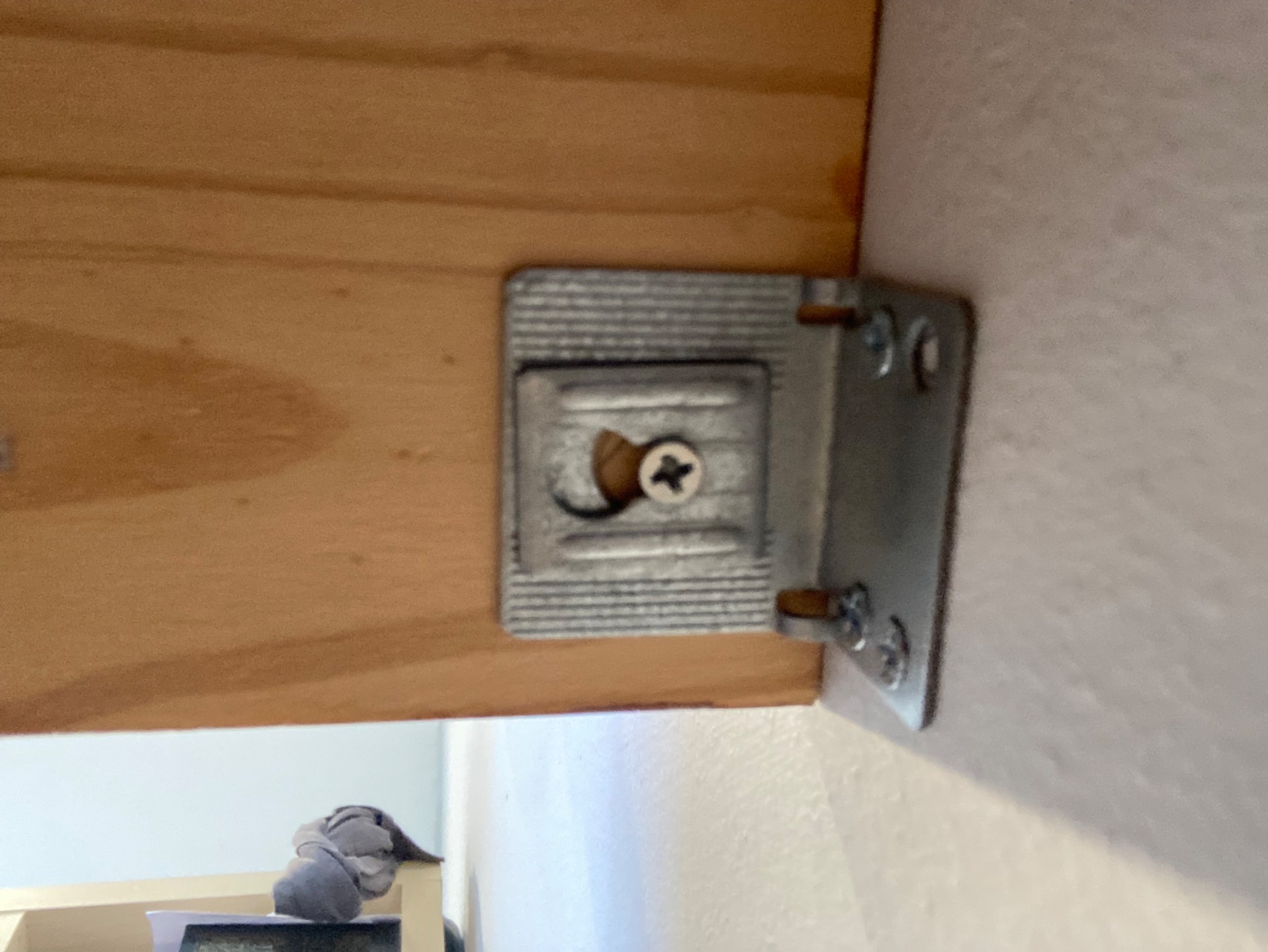 Bracket fastening shelf to wall