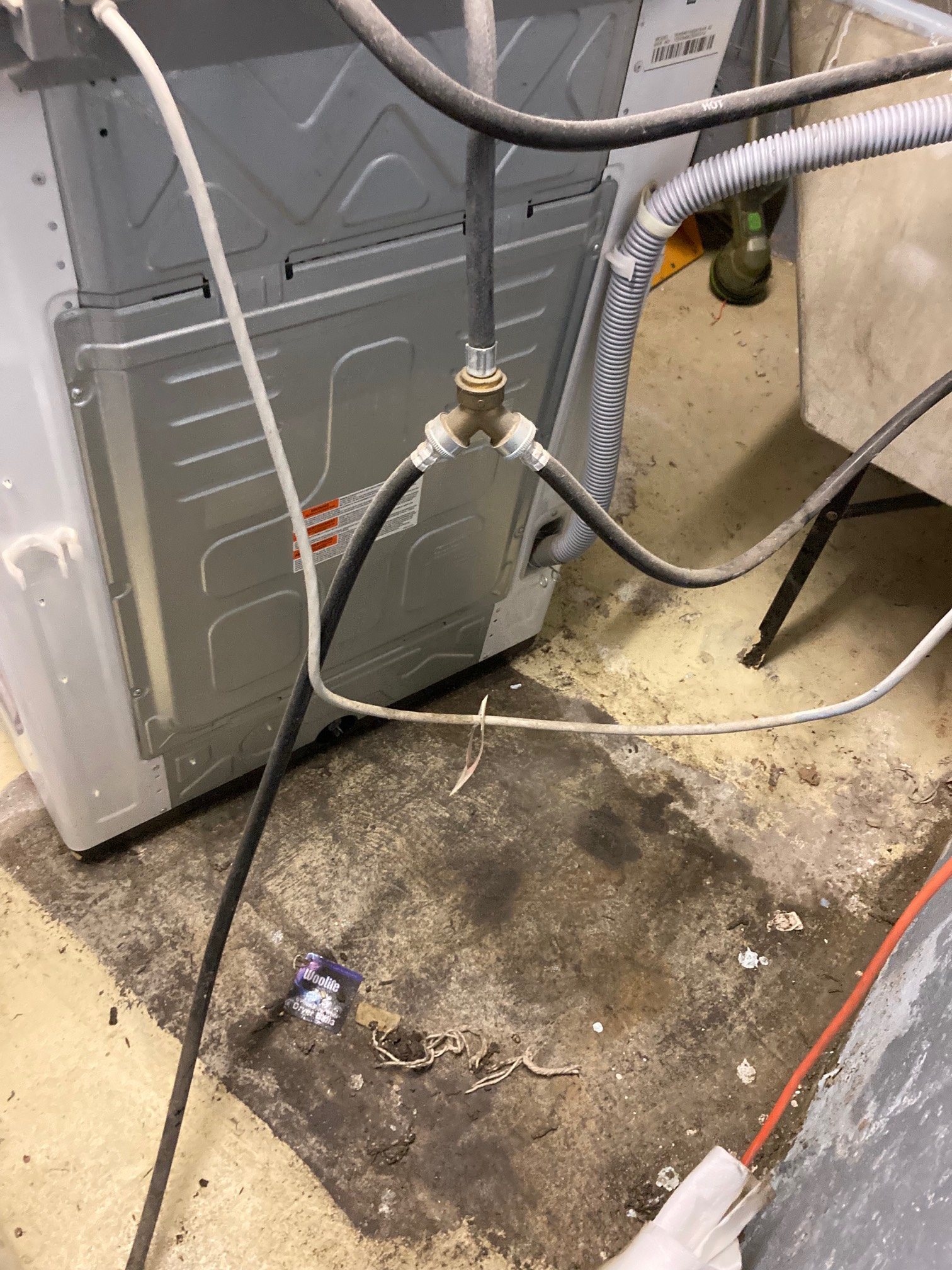 Washing machine next to a square of wet grime