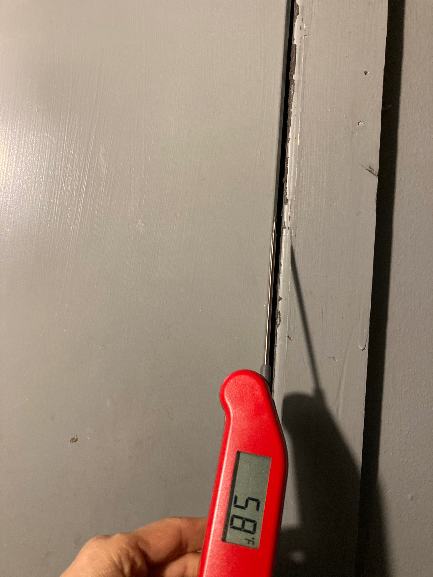 Door gap with thermometer reading 58°