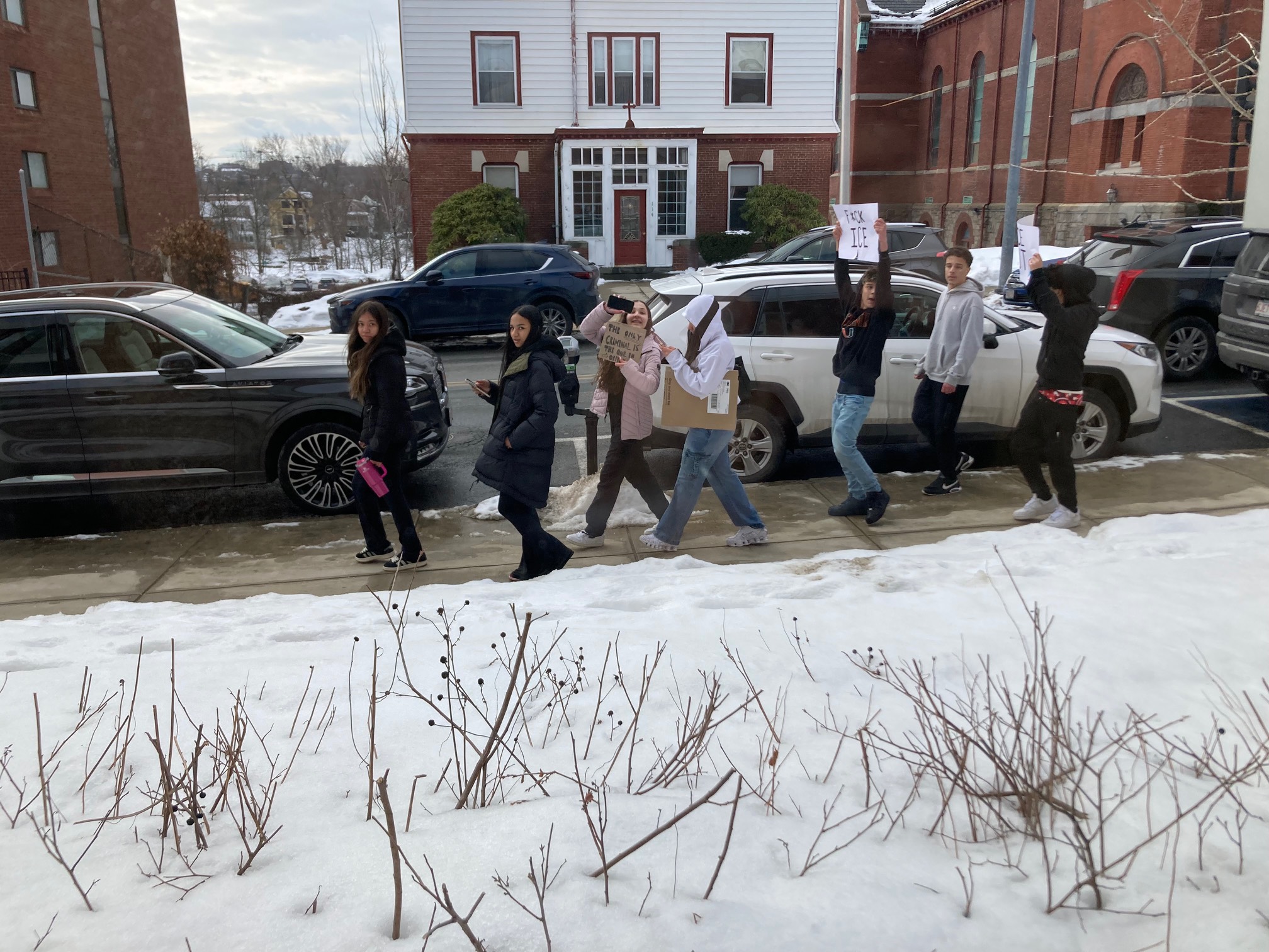 High schoolers holding up anti-ICE signs