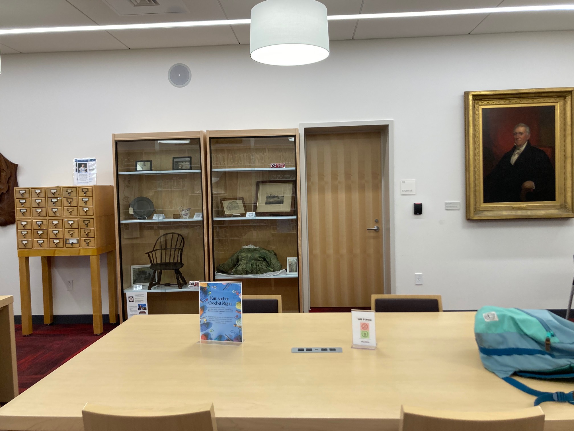 Room with table, display cases, and paintings