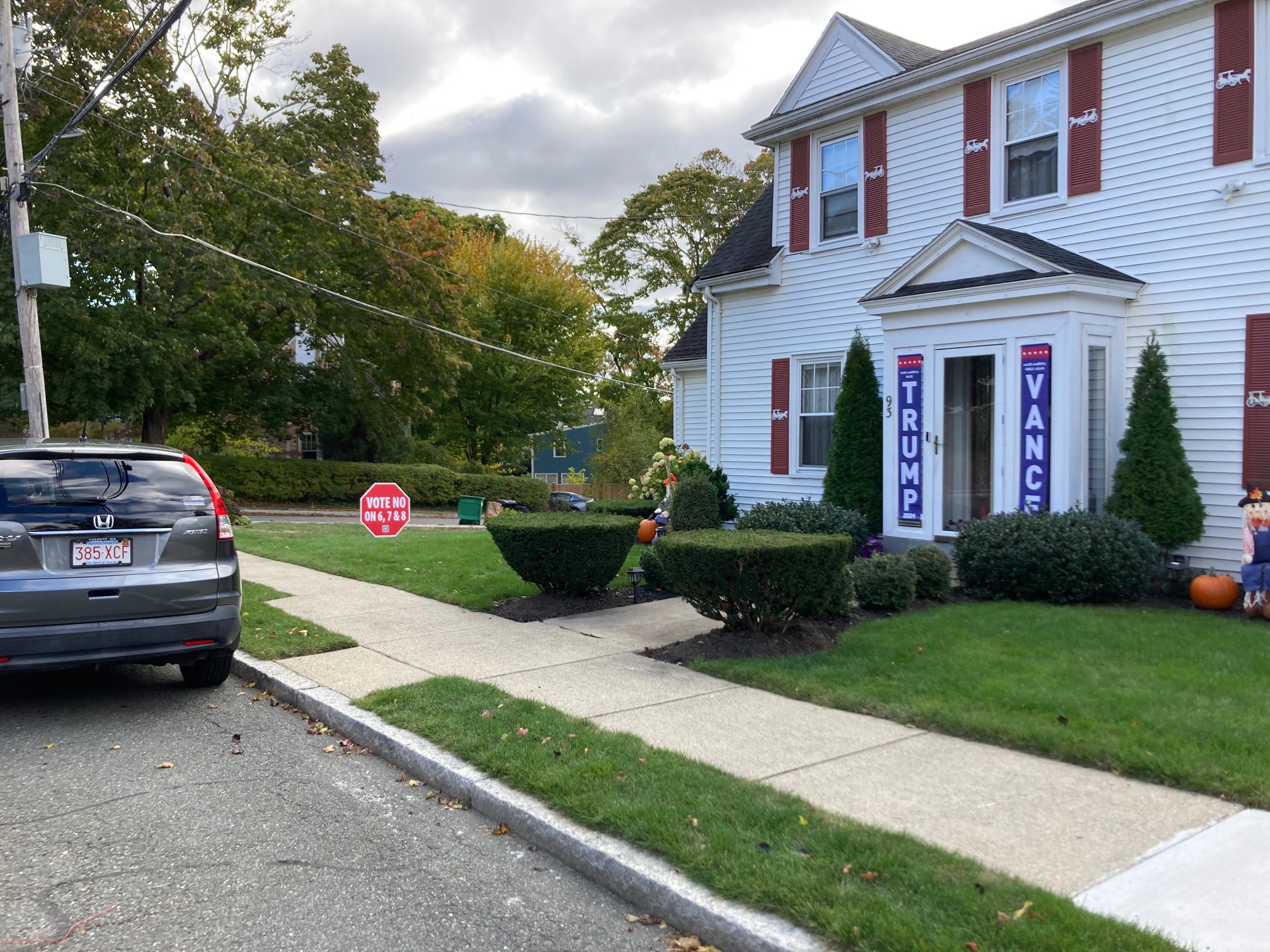 House with Trump and Vance banners and a vote no sign