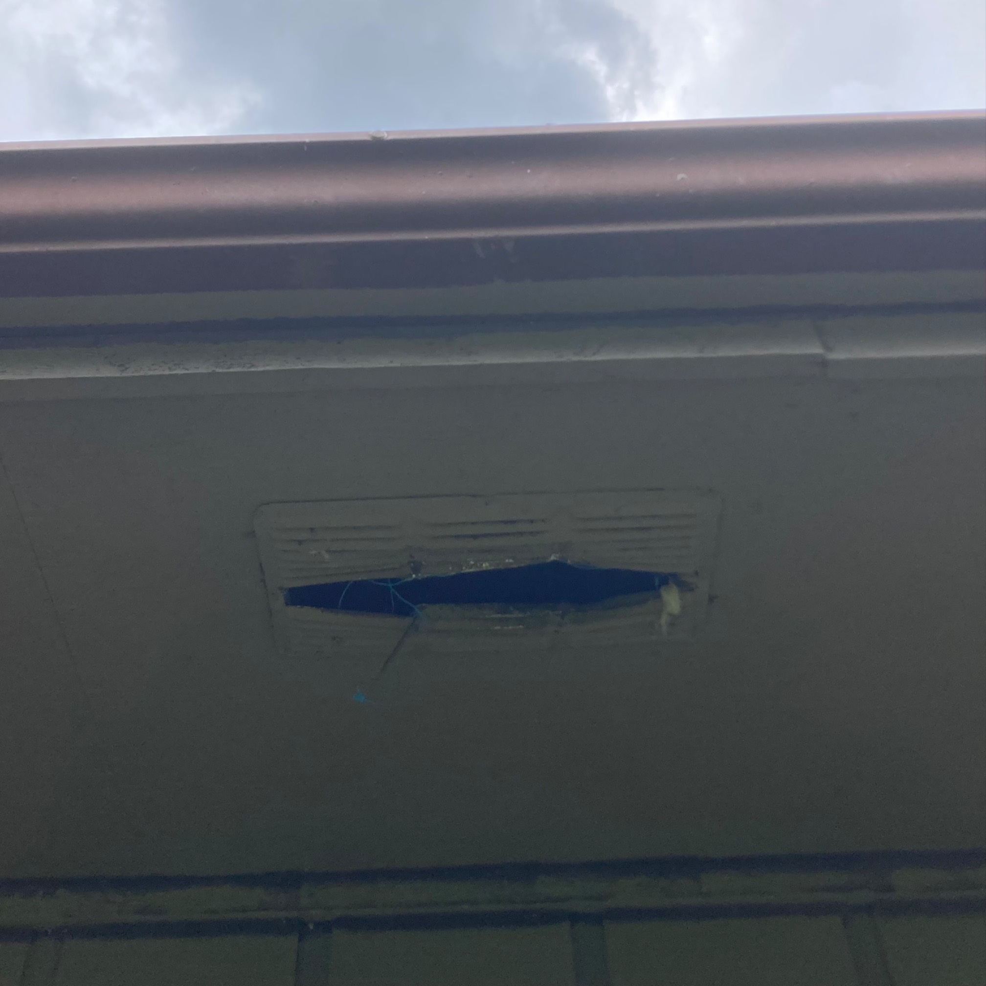 Roof ledge with plastic vent that has been ripped open