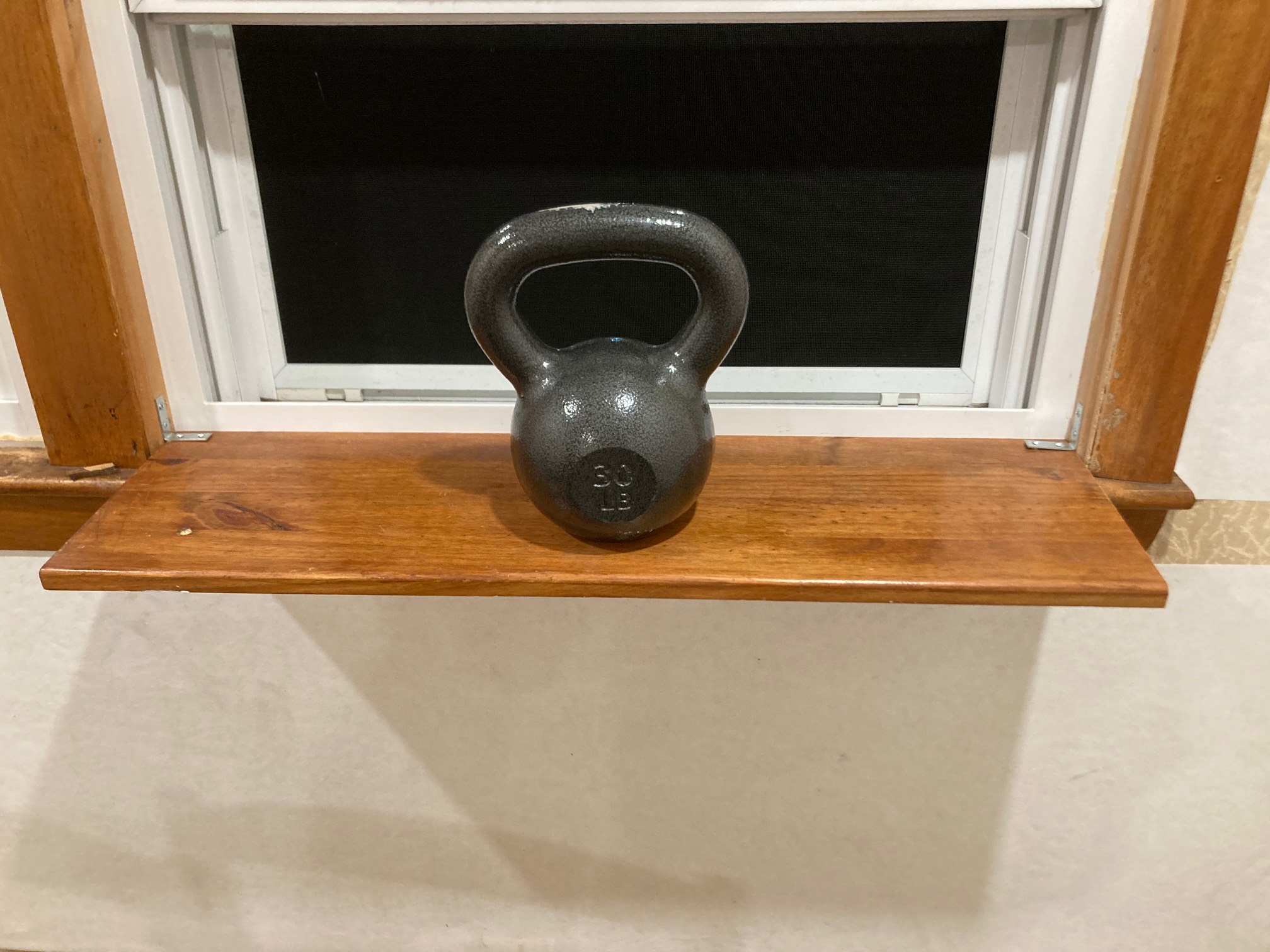 S helf extending from window stool with 30-lb. kettlebell on it