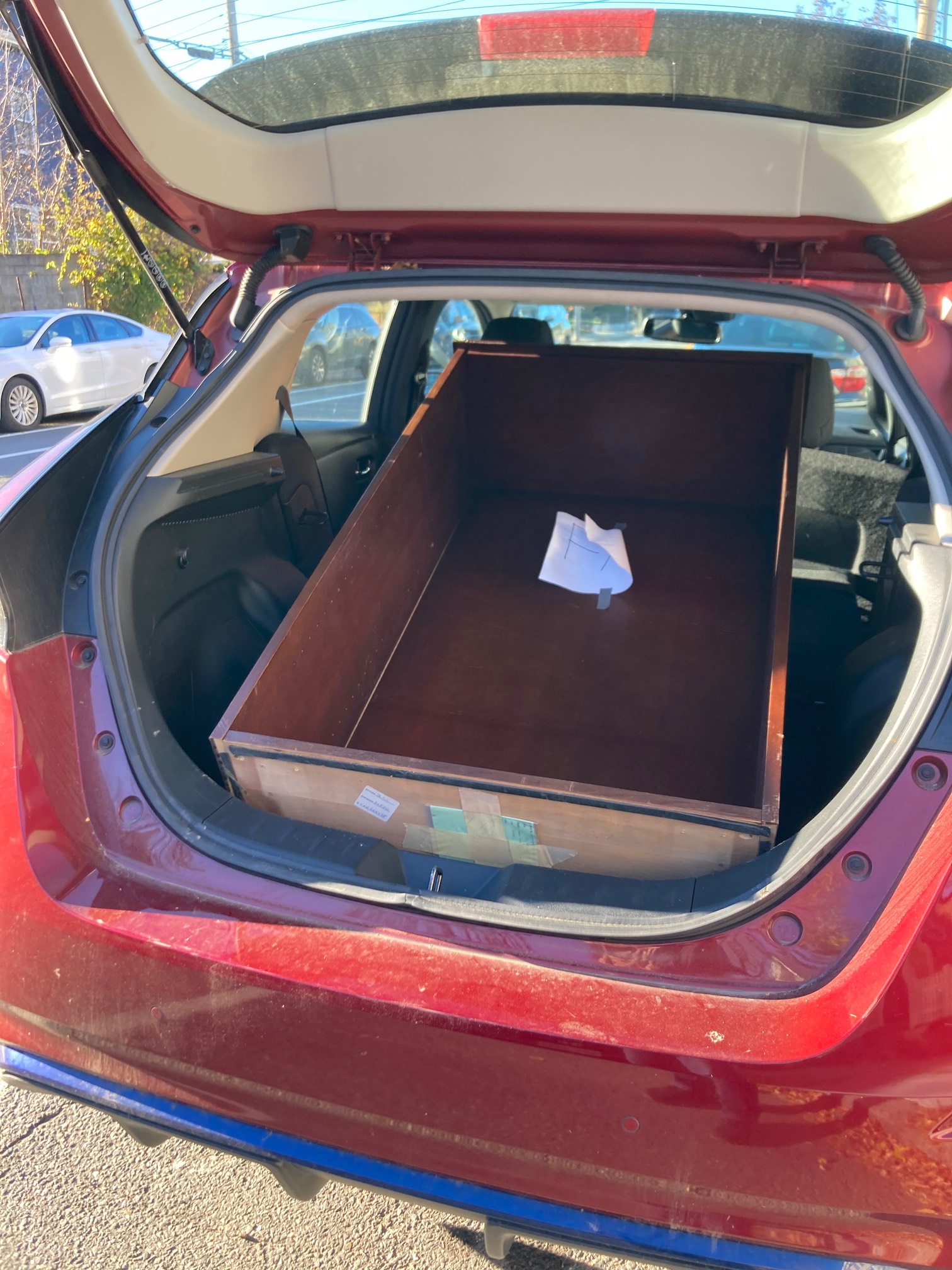 Hatchback of car open with a bookcase in it